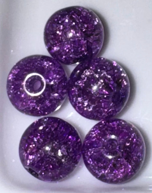 Five round purple glitter beads with a central hole, arranged on a white background.