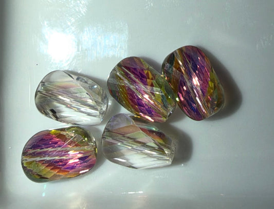 Five faceted glass beads with a clear base and iridescent rainbow swirls of purple, pink, green, and gold, arranged on a white surface.