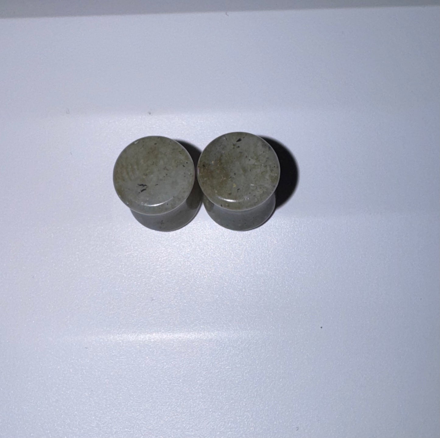 Two labradorite ear gauges on a white background