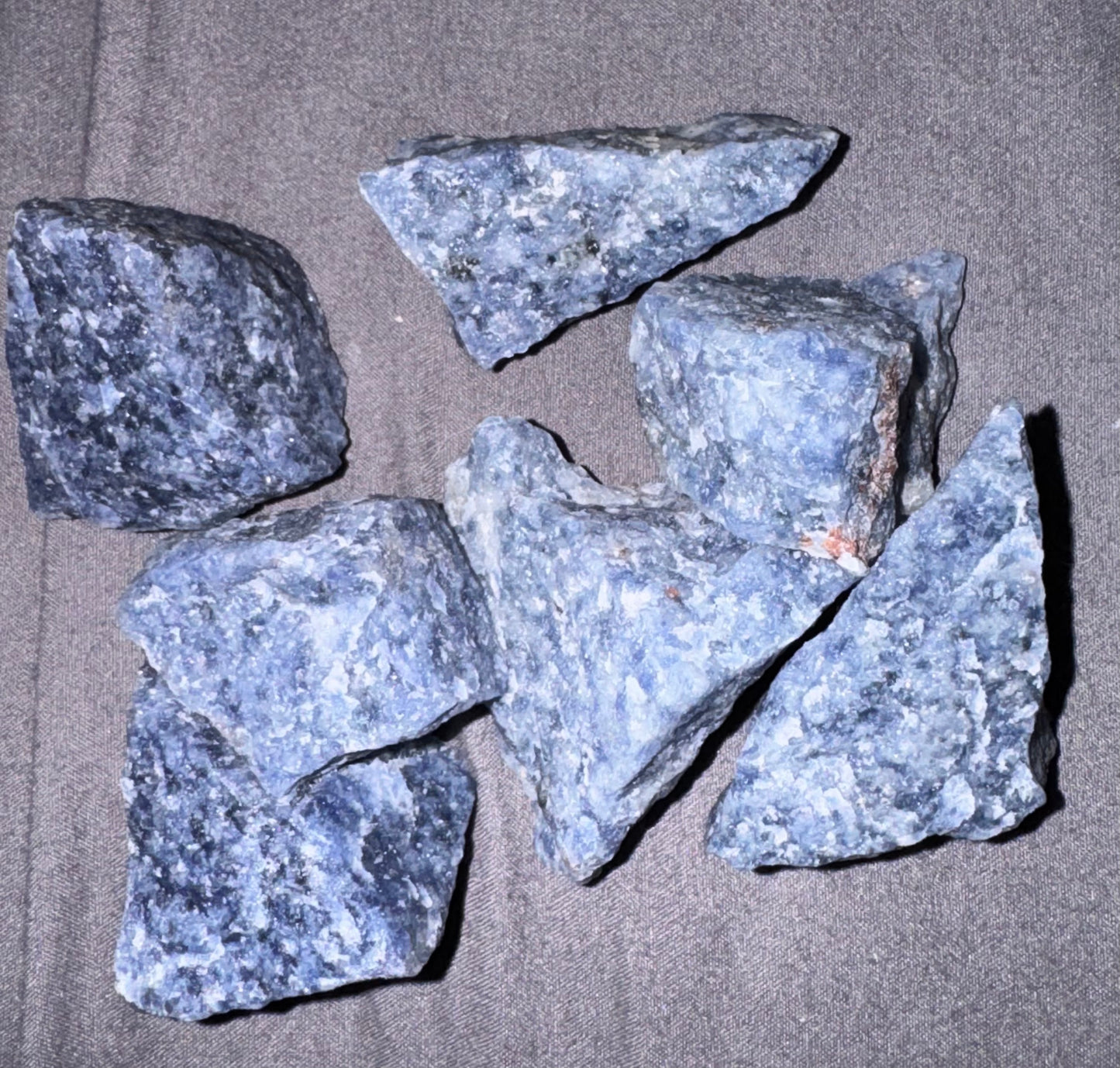 Five blue rocks on a gray surface