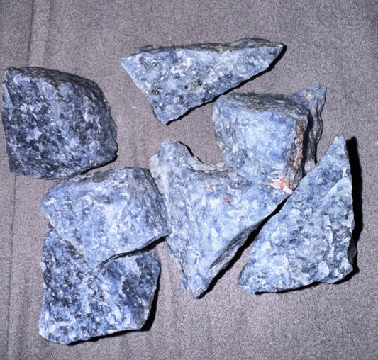 Five blue rocks on a gray surface