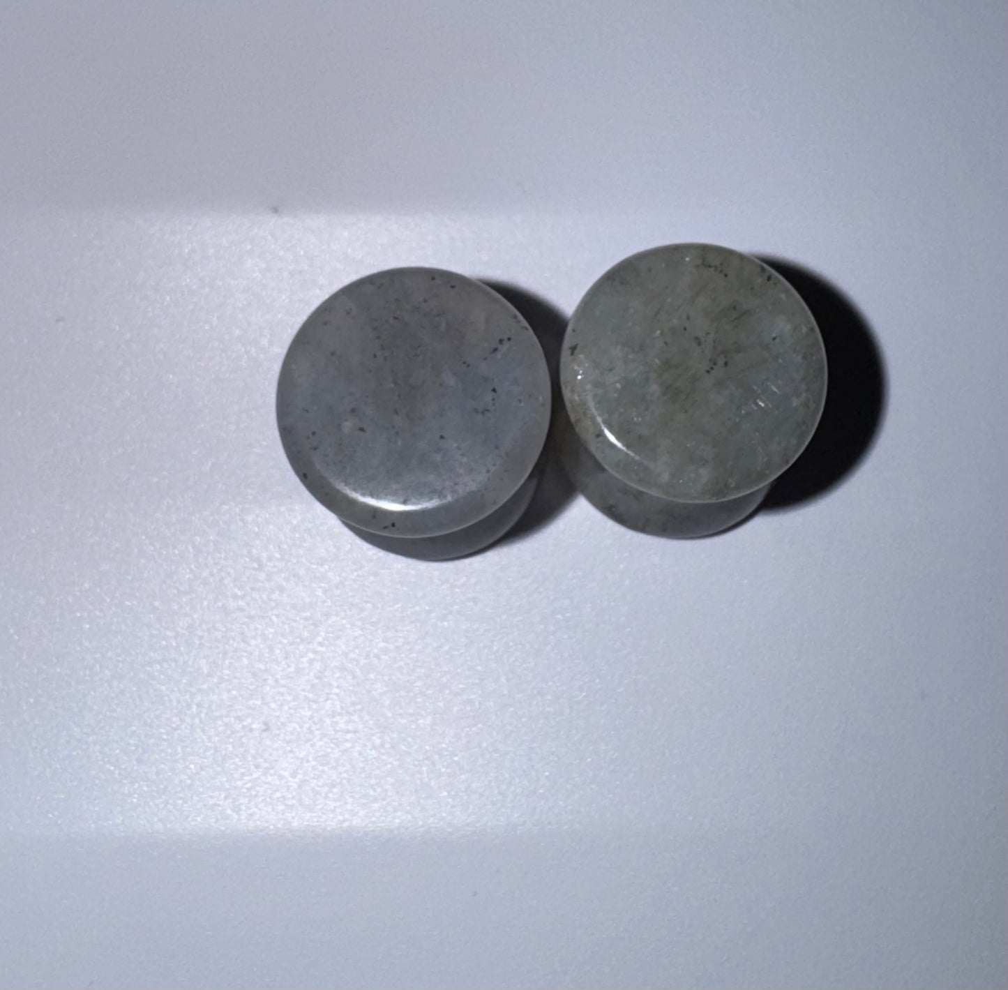 Two labradorite ear gauges on a white background