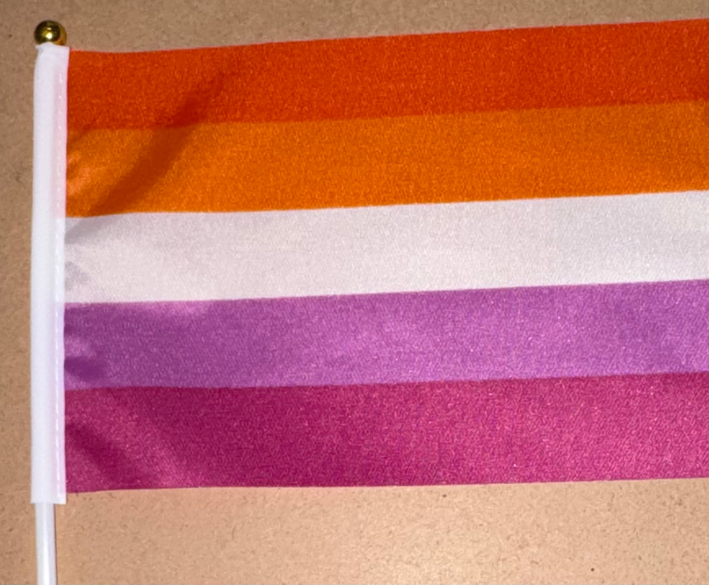 Flag with orange, white, and pink horizontal stripes on a beige background