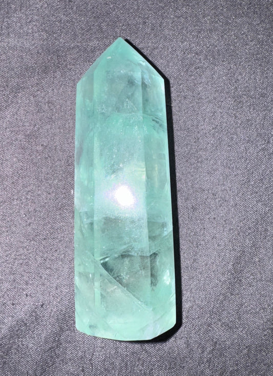 Green crystal on a gray fabric background