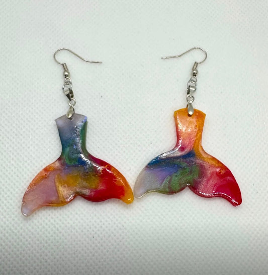Colorful mermaid tail earrings on a white background