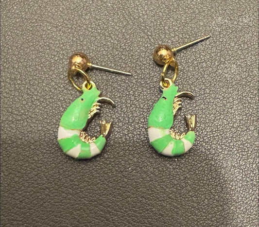 Green and white shrimp-shaped earrings on a gray textured background