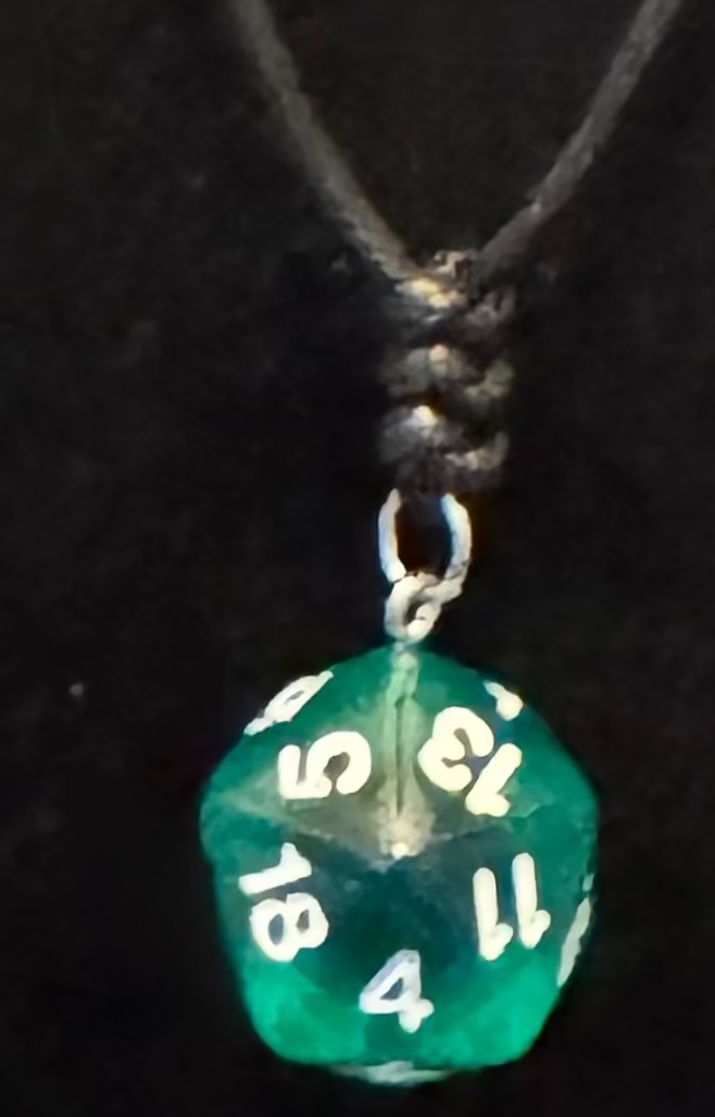 A green translucent d20 die-cut pendant necklace with white numbering, hanging from a black cord on a black display bust.