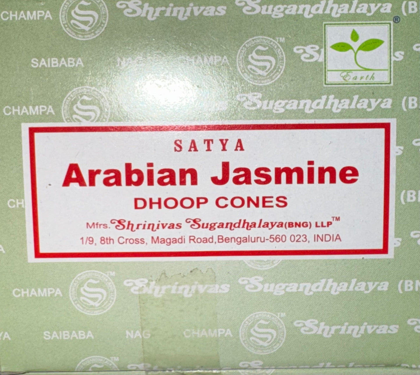 A close-up of a green box labeled 'SATYA Arabian Jasmine DHOOP CONES' with a white central label and repeated Shrinivas Sugandhalaya branding on the packaging.