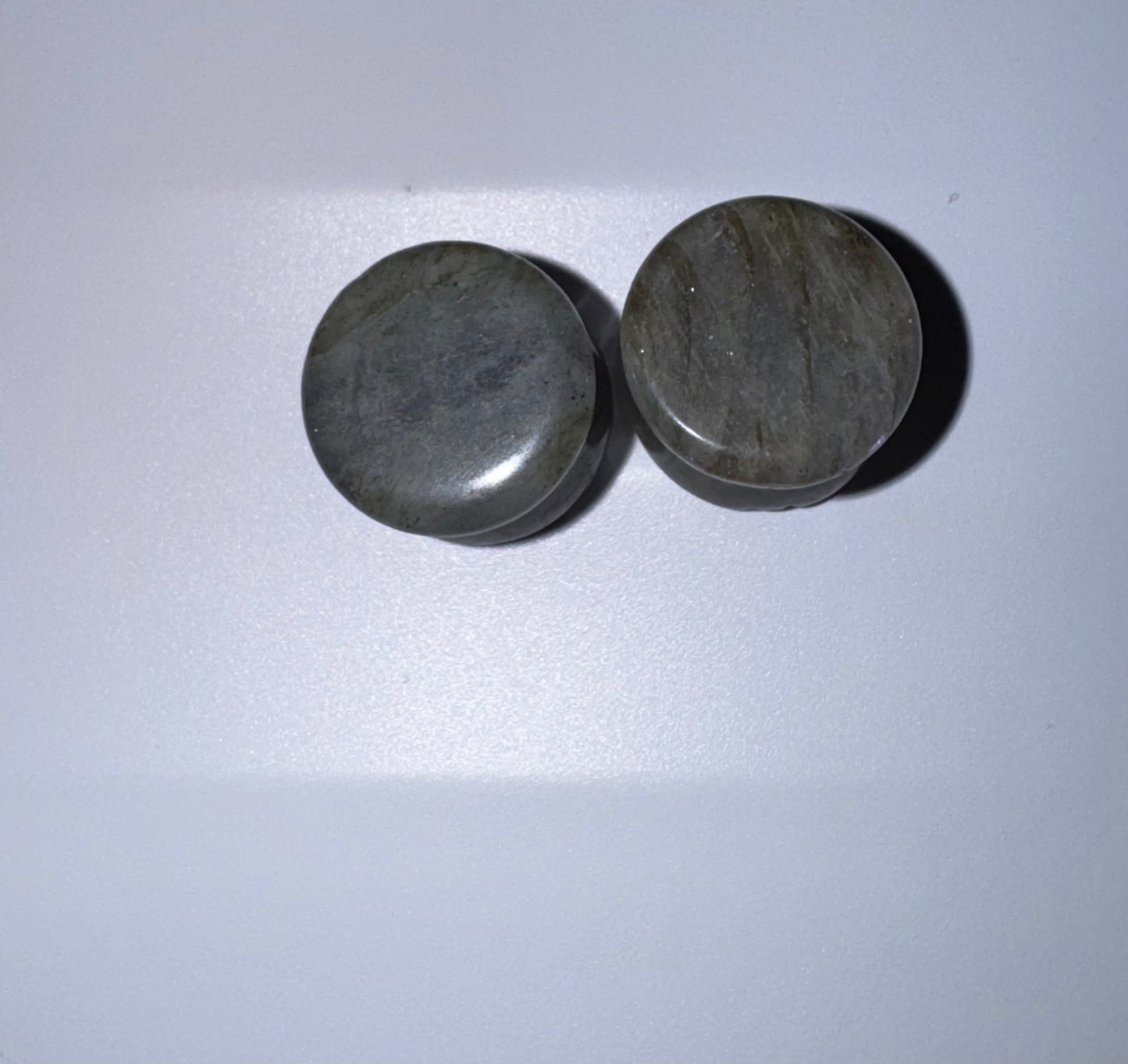 Two labradorite ear gauges on a white background