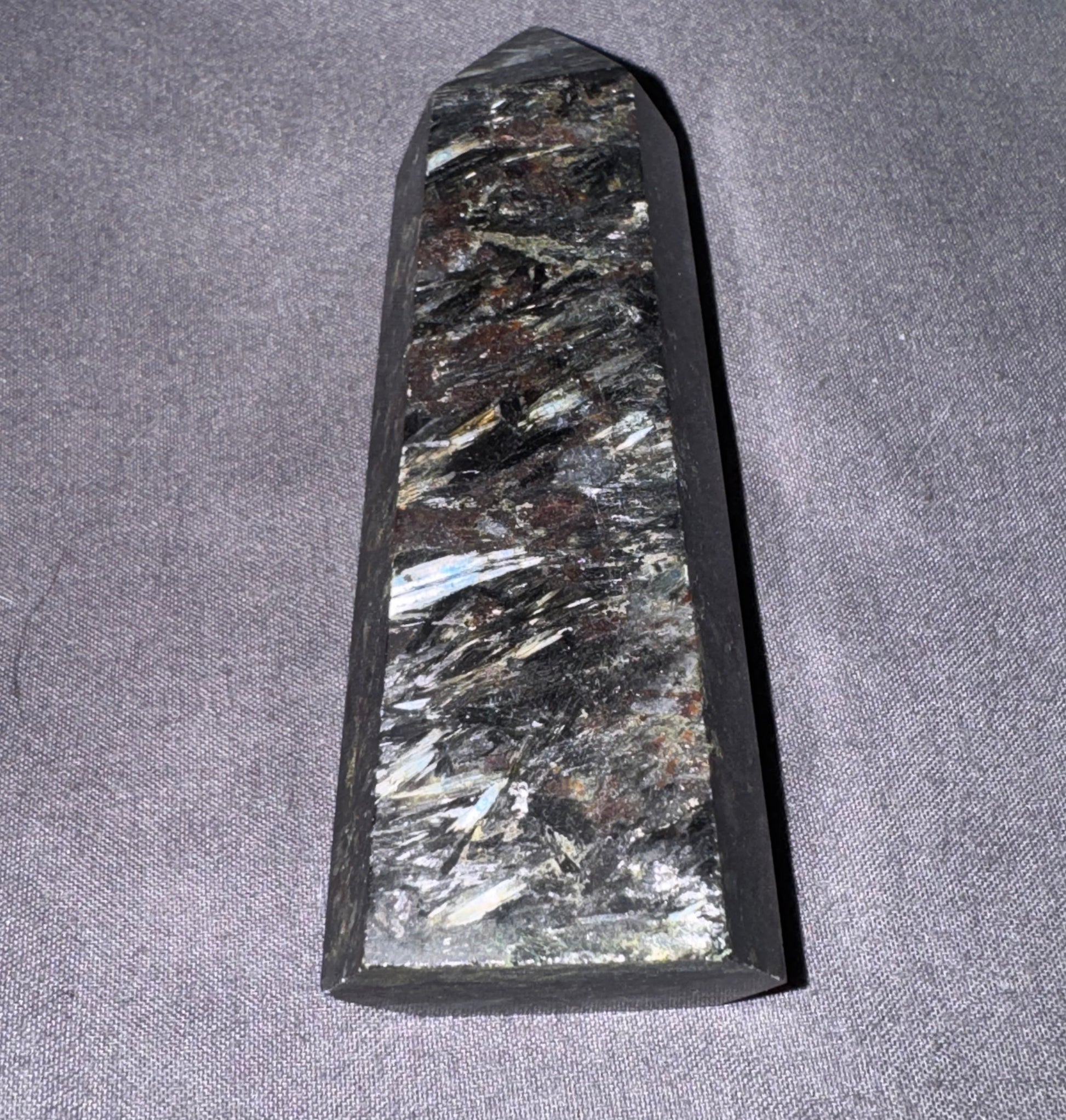 Decorative stone with crystal-like inclusions on a gray fabric background