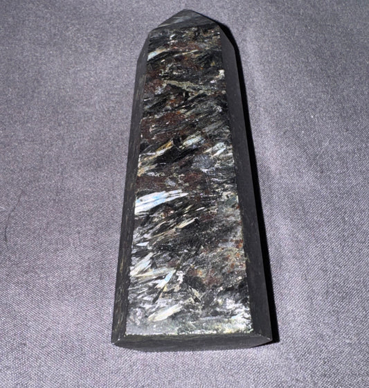 Decorative stone with crystal-like inclusions on a gray fabric background