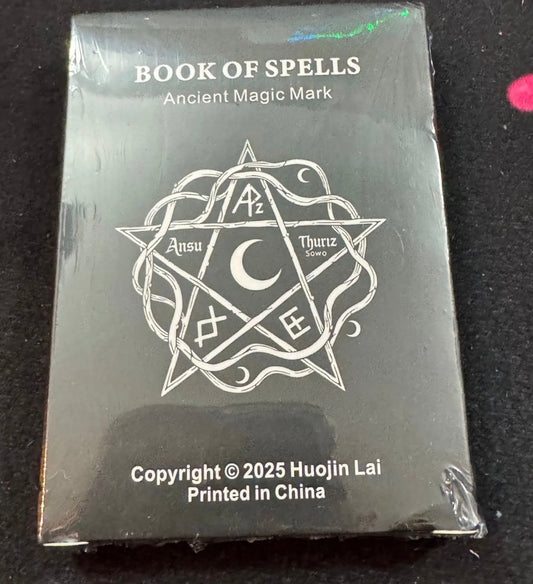 Packaged product titled 'Book of Spells' with magickal symbols on a black background
