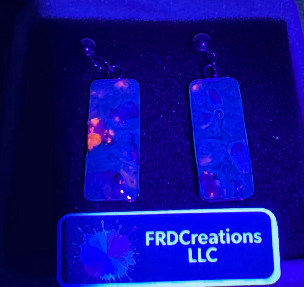 UV earrings with colorful design under black light.