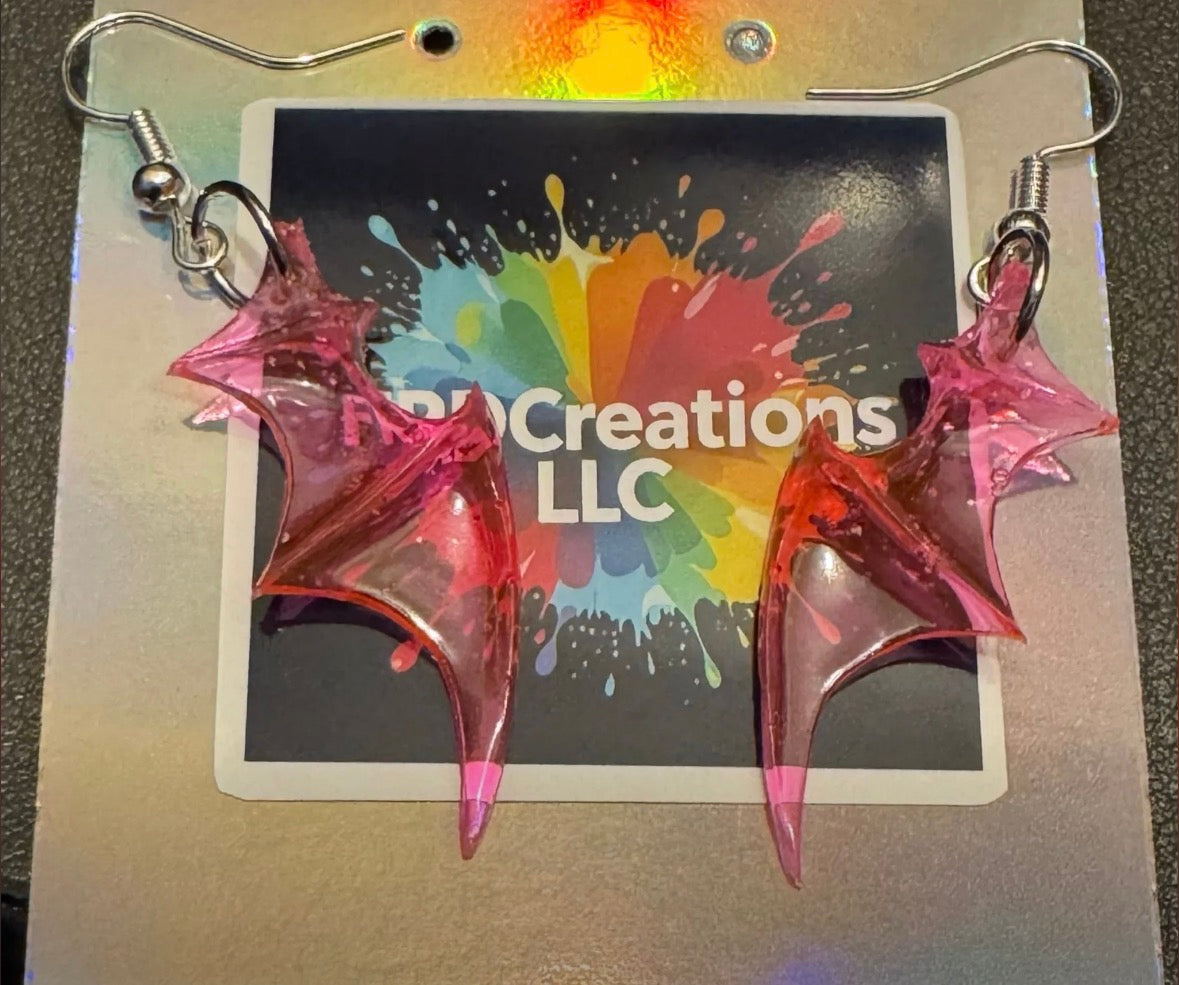 Pink dragon wing earrings on a card 