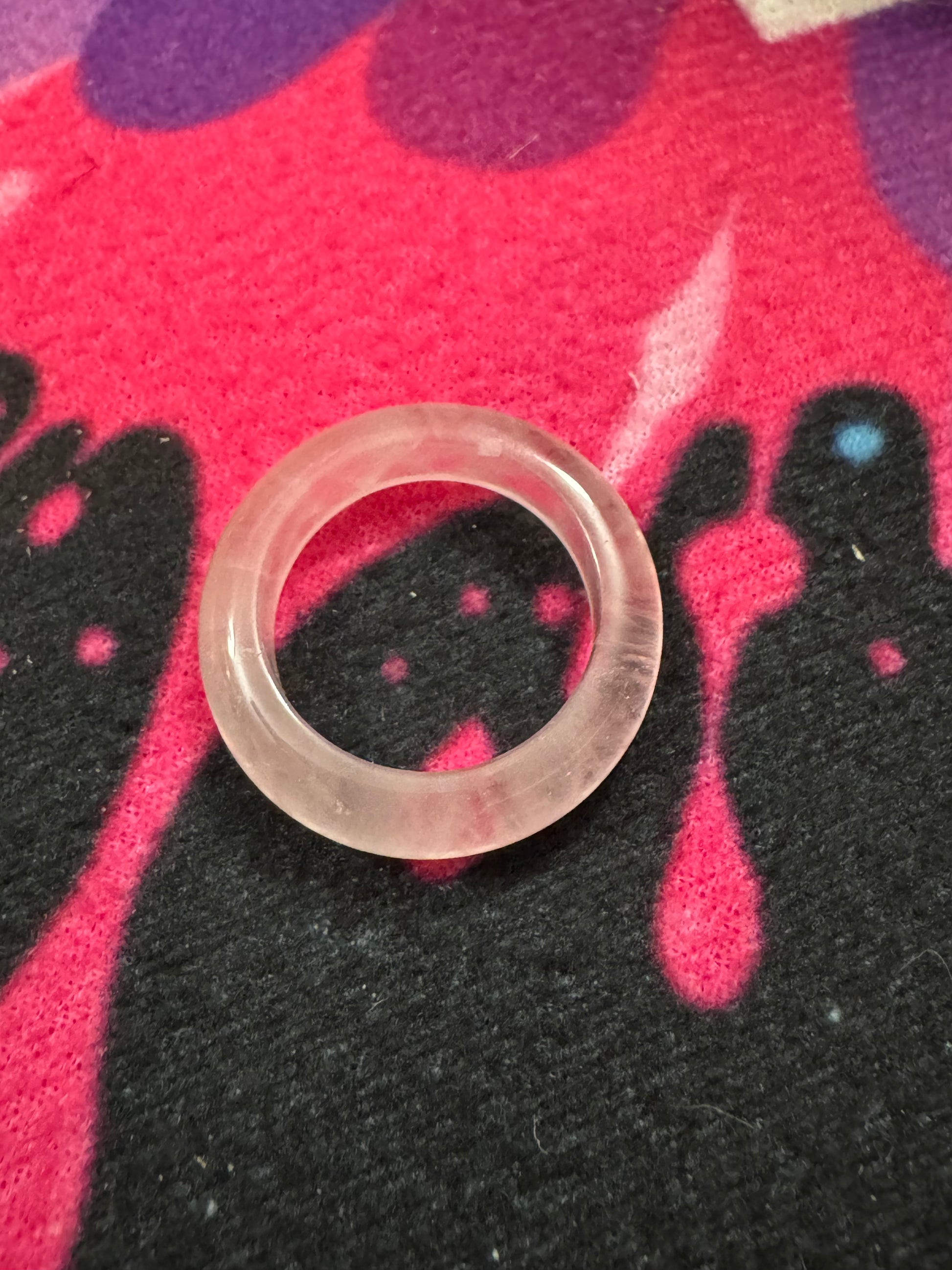 Rose Quartz Ring on a colorful fabric background.