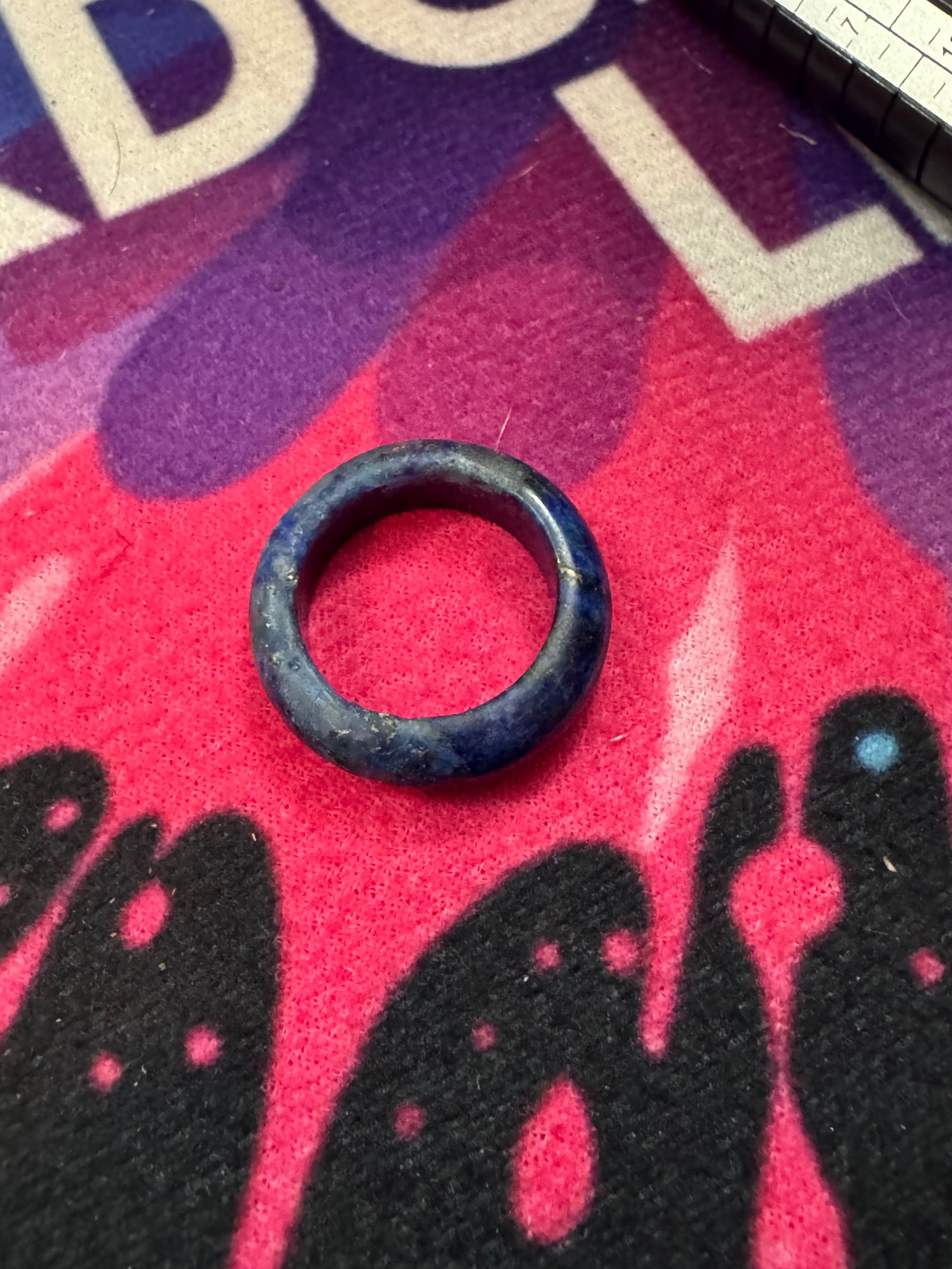 Lapis Lazuli ring on a colorful fabric background with black silhouettes