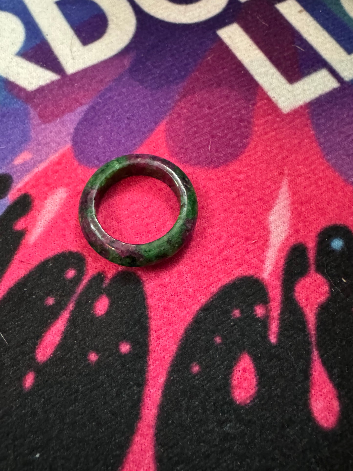 Ruby and Zoisite ring ring on a colorful background with abstract designs