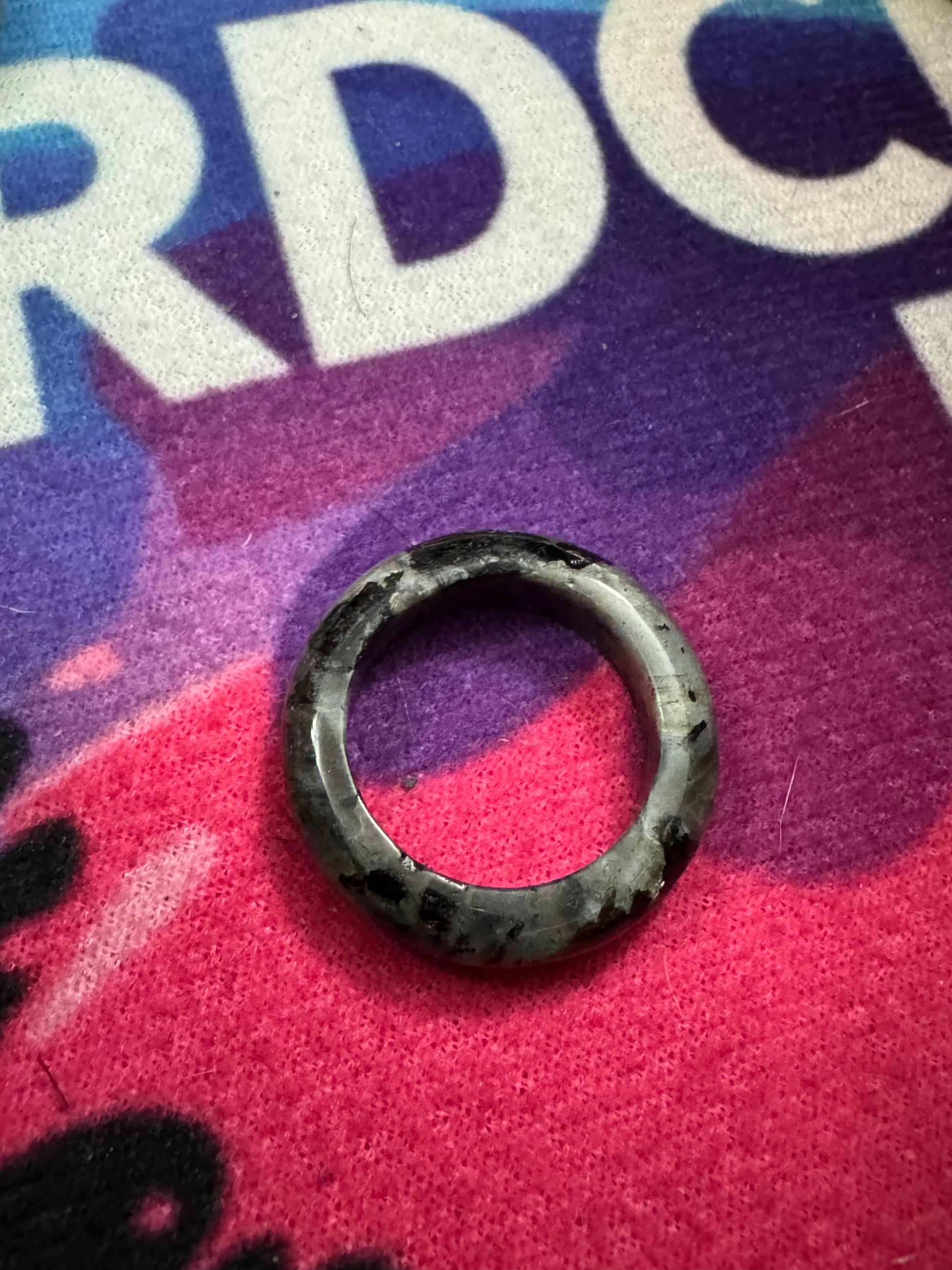 Labradorite ring on a colorful fabric background with text
