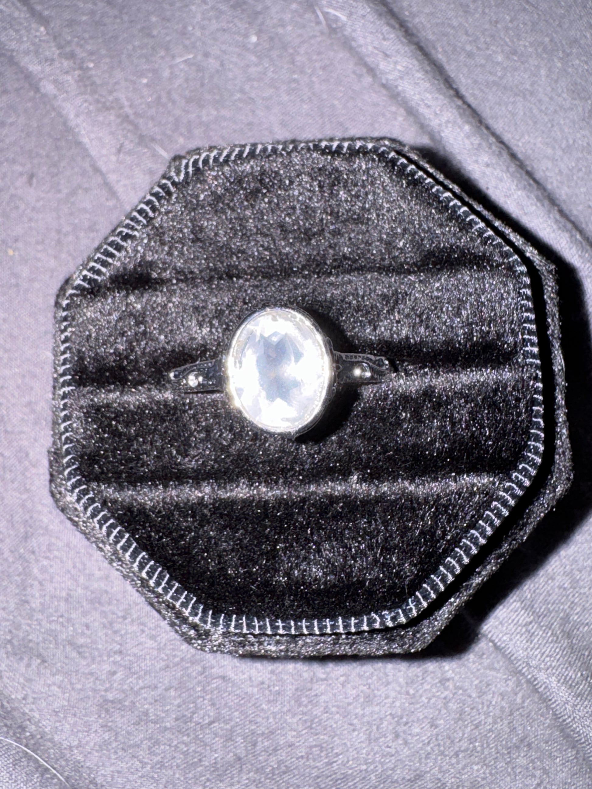 Quartz ring in a black velvet box on a gray surface