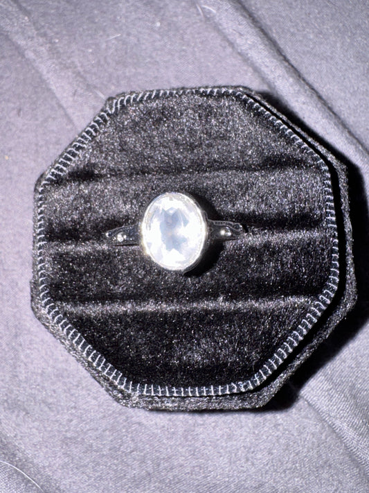 Quartz ring in a black velvet box on a gray surface