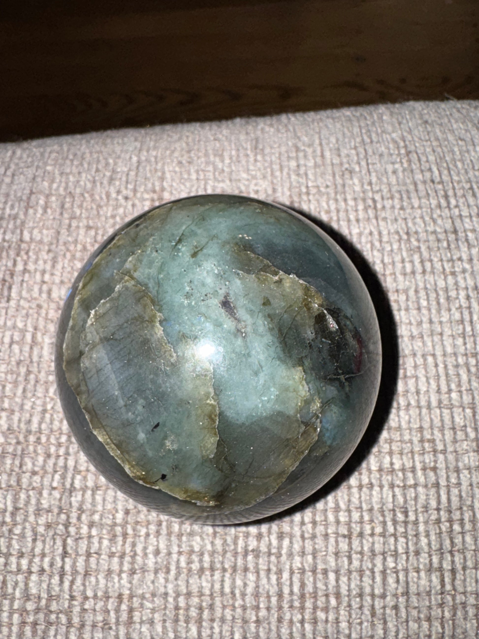 Greenish-blue stone on a textured fabric surface