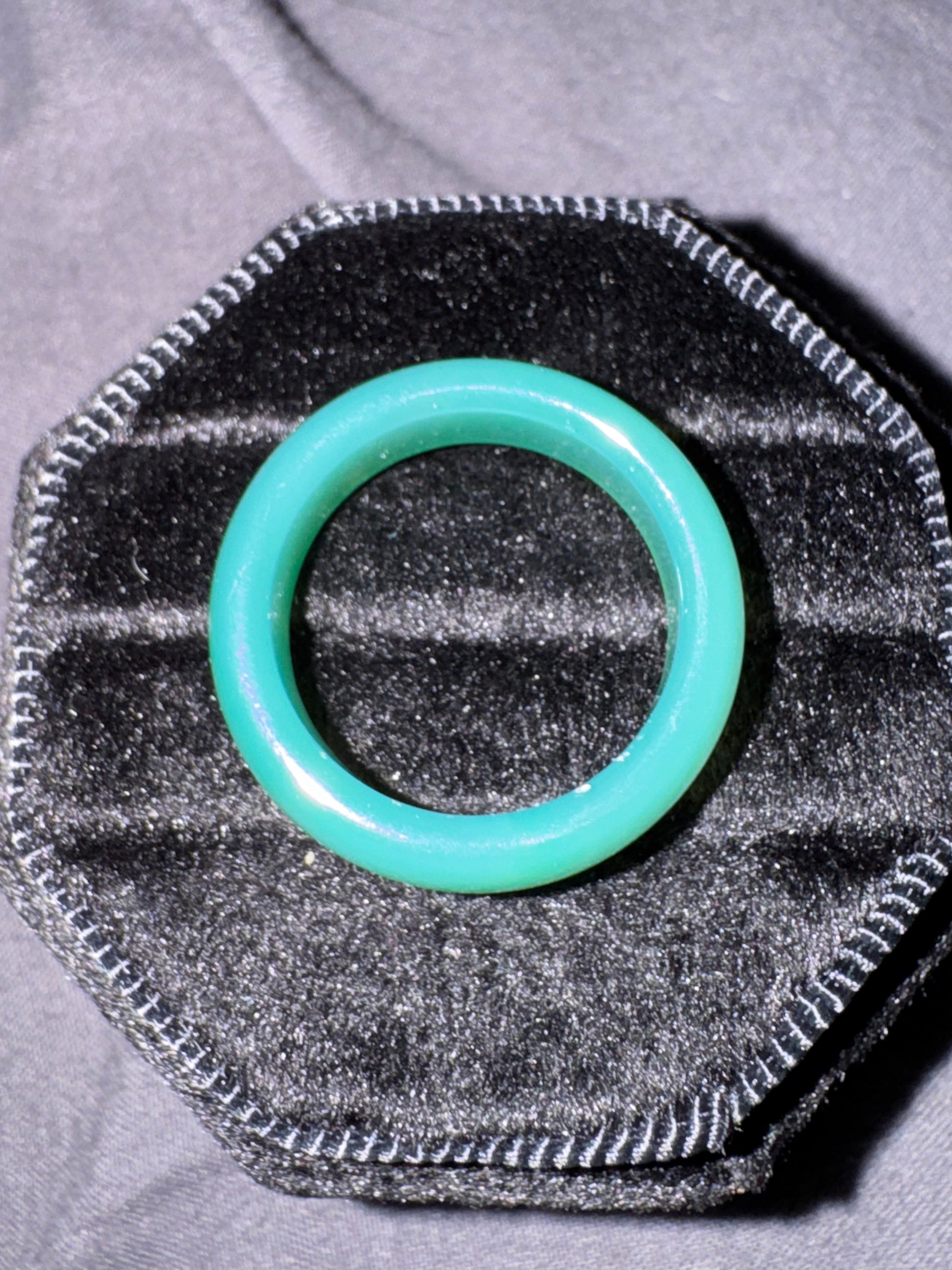 Turquoise o-ring on a textured gray background