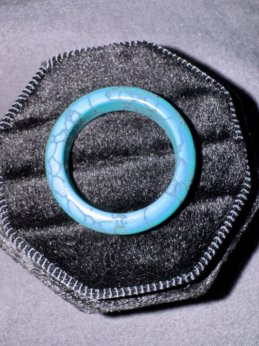 Turquoise ring on a black textured stand