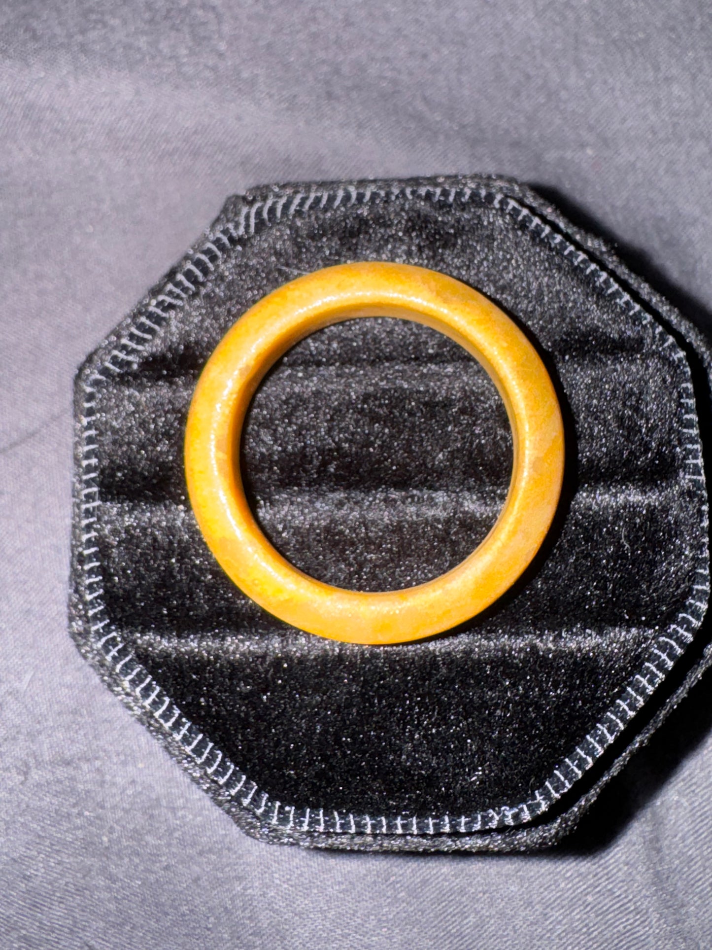 Yellow ring on a black hexagonal cushion against a gray background