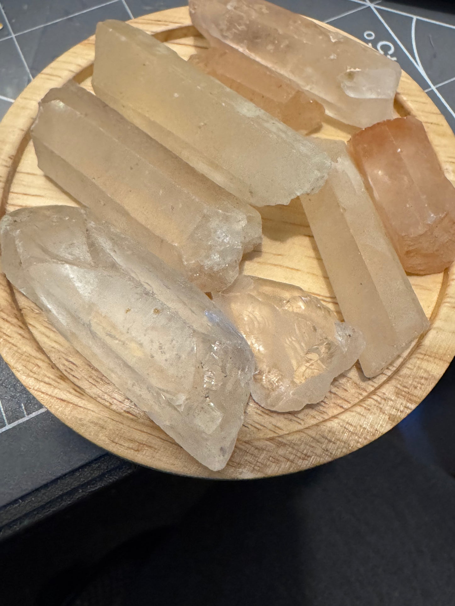 Clear crystal sticks on a wooden stand with a grid background