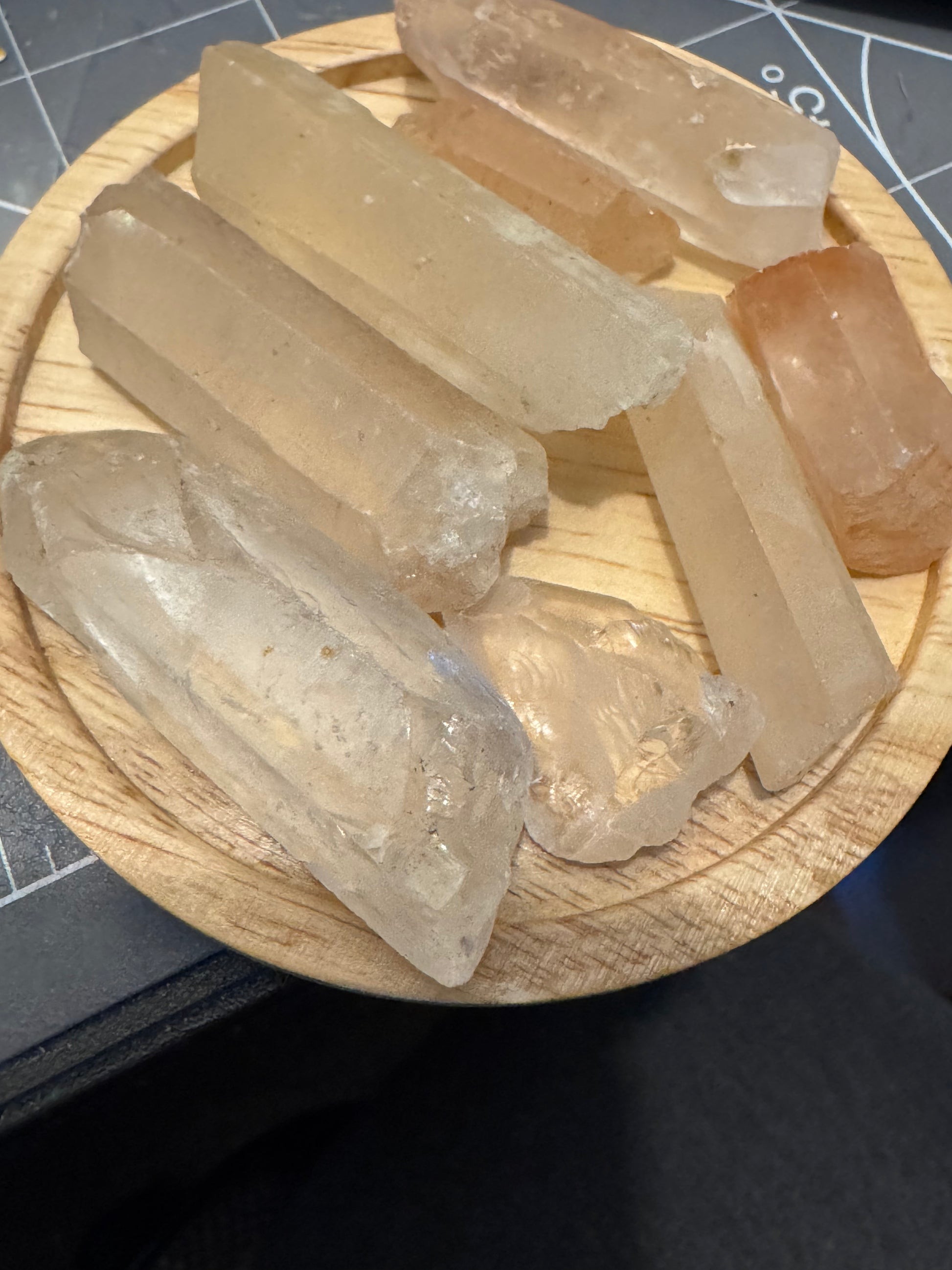 Clear crystal sticks on a wooden stand with a grid background