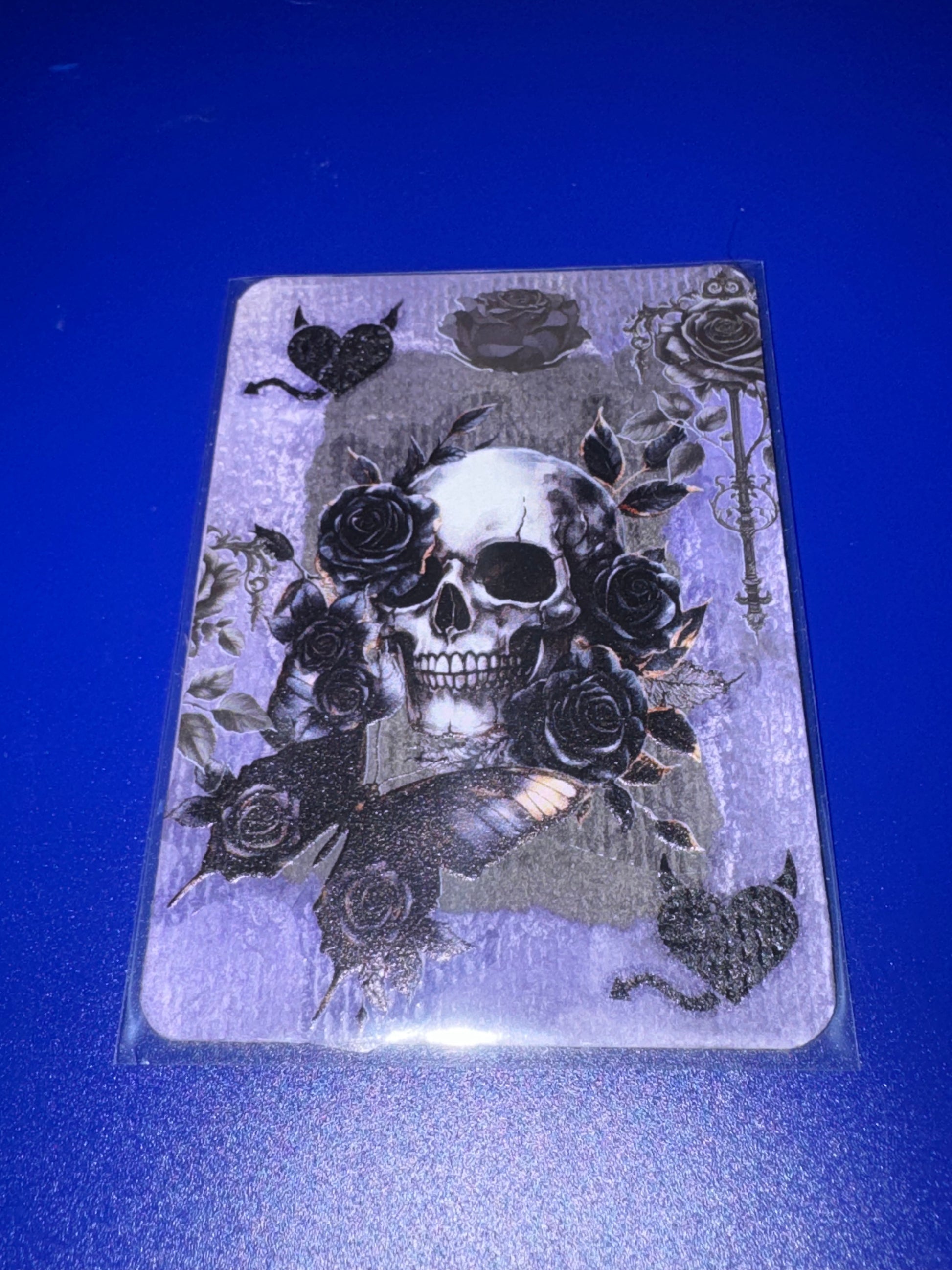 Card with a skull and roses design on a blue background