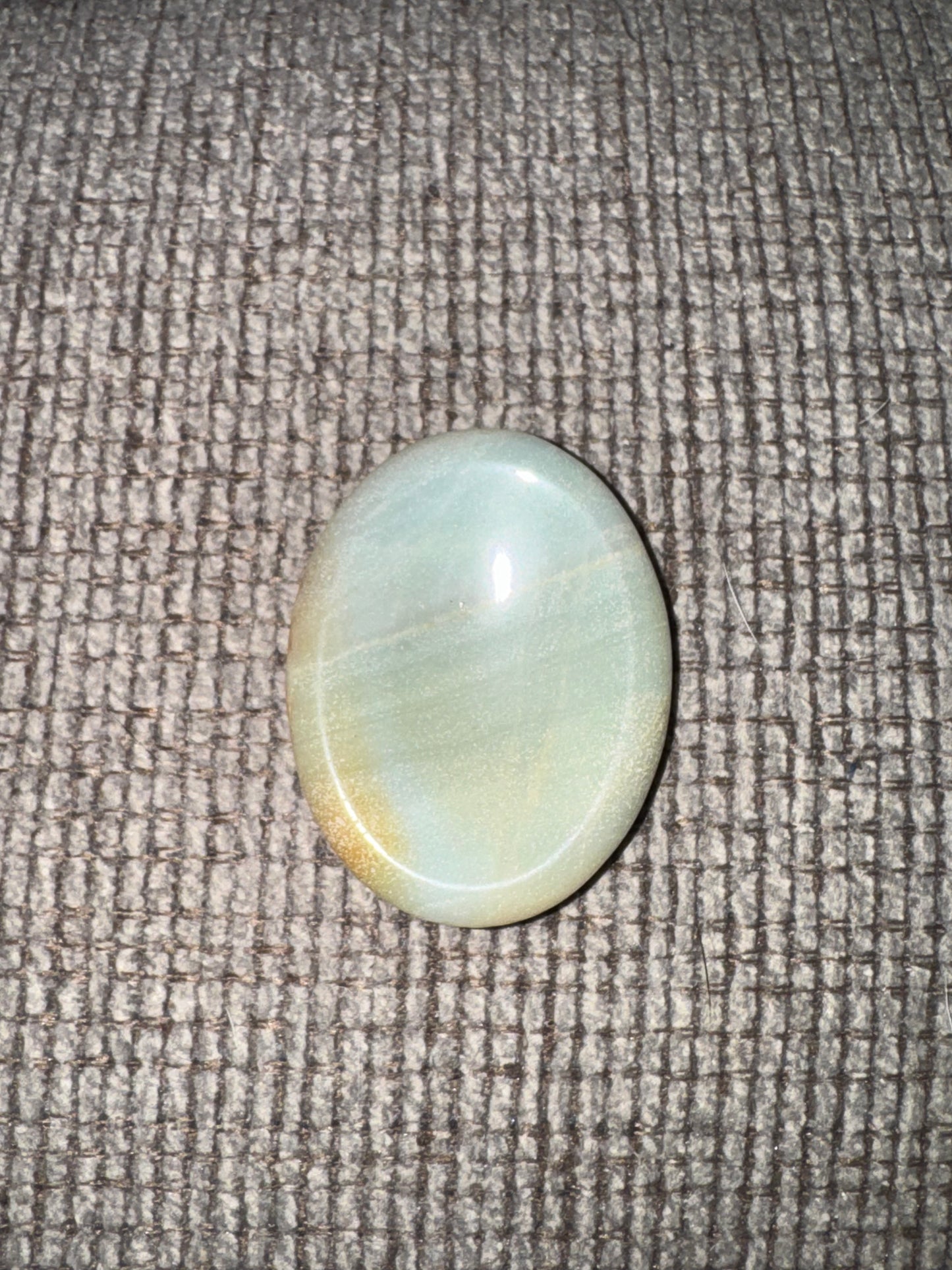 Round light blue stone on a textured gray surface