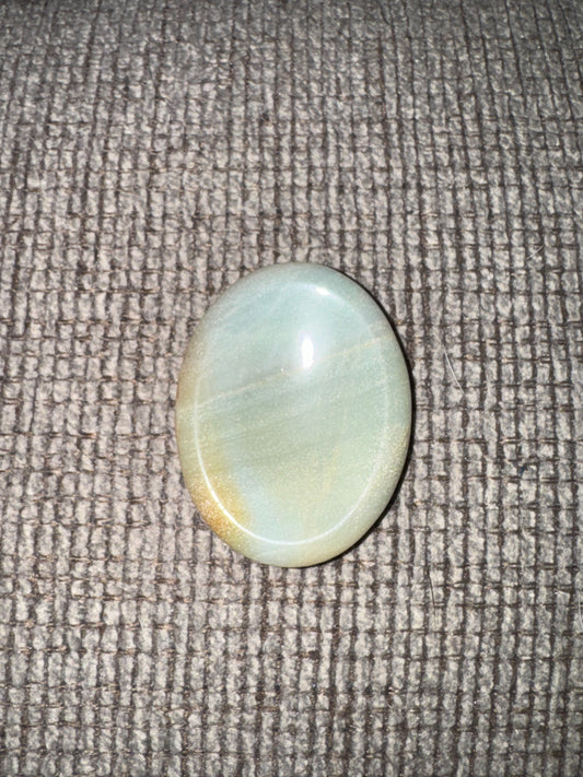 Round light blue stone on a textured gray surface