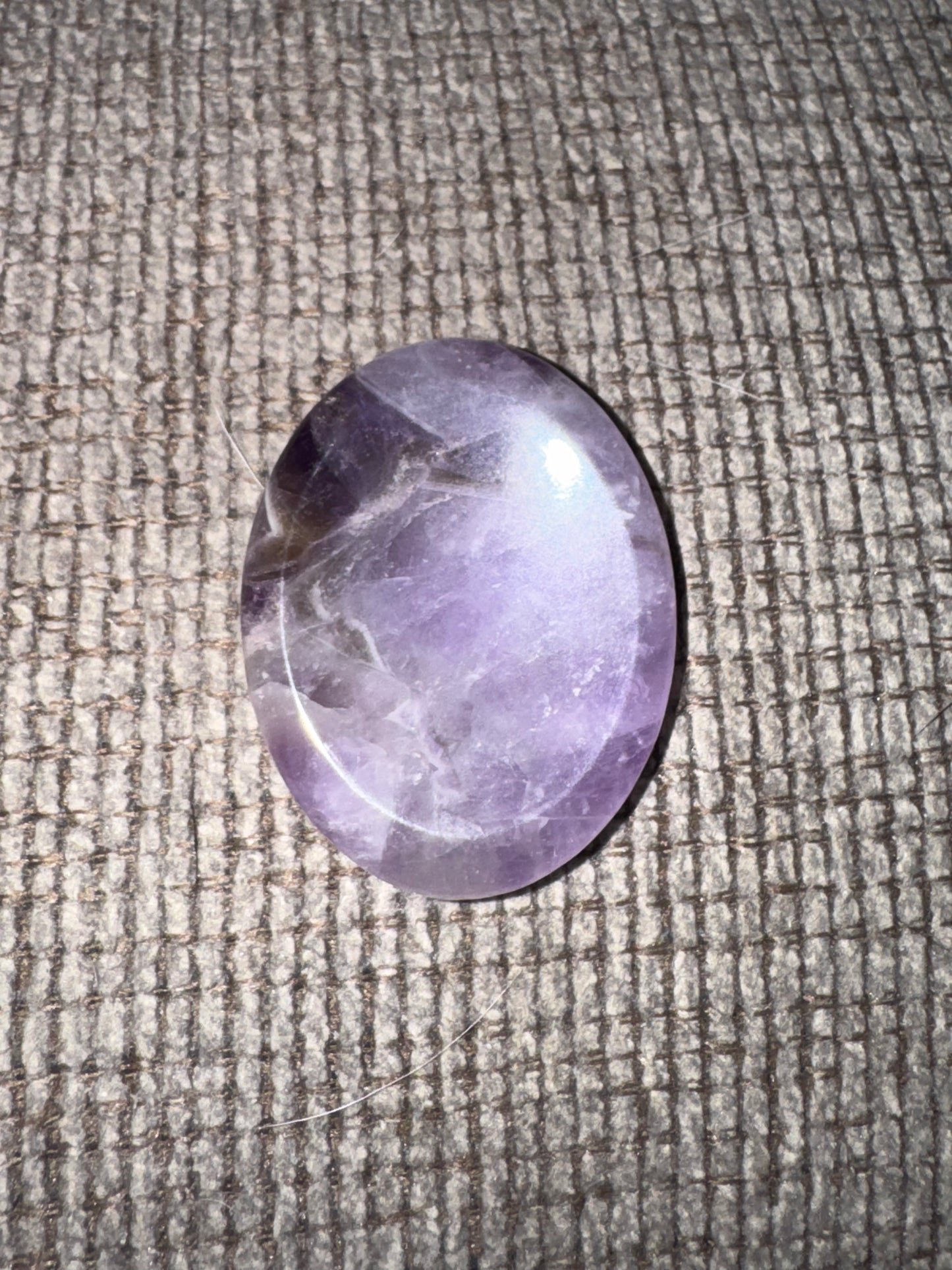 Purple stone on a textured fabric surface