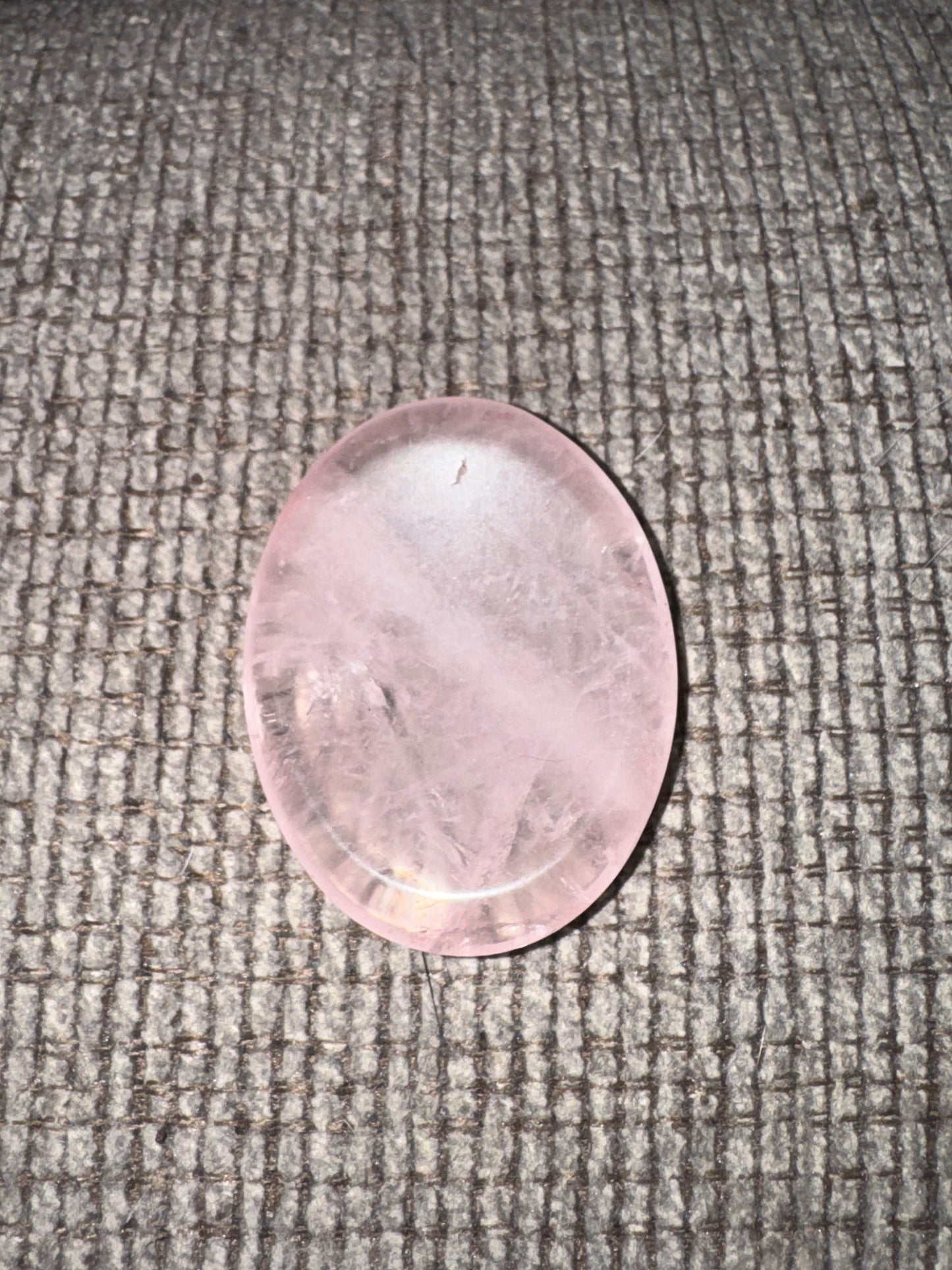Rose quartz stone on a textured gray surface