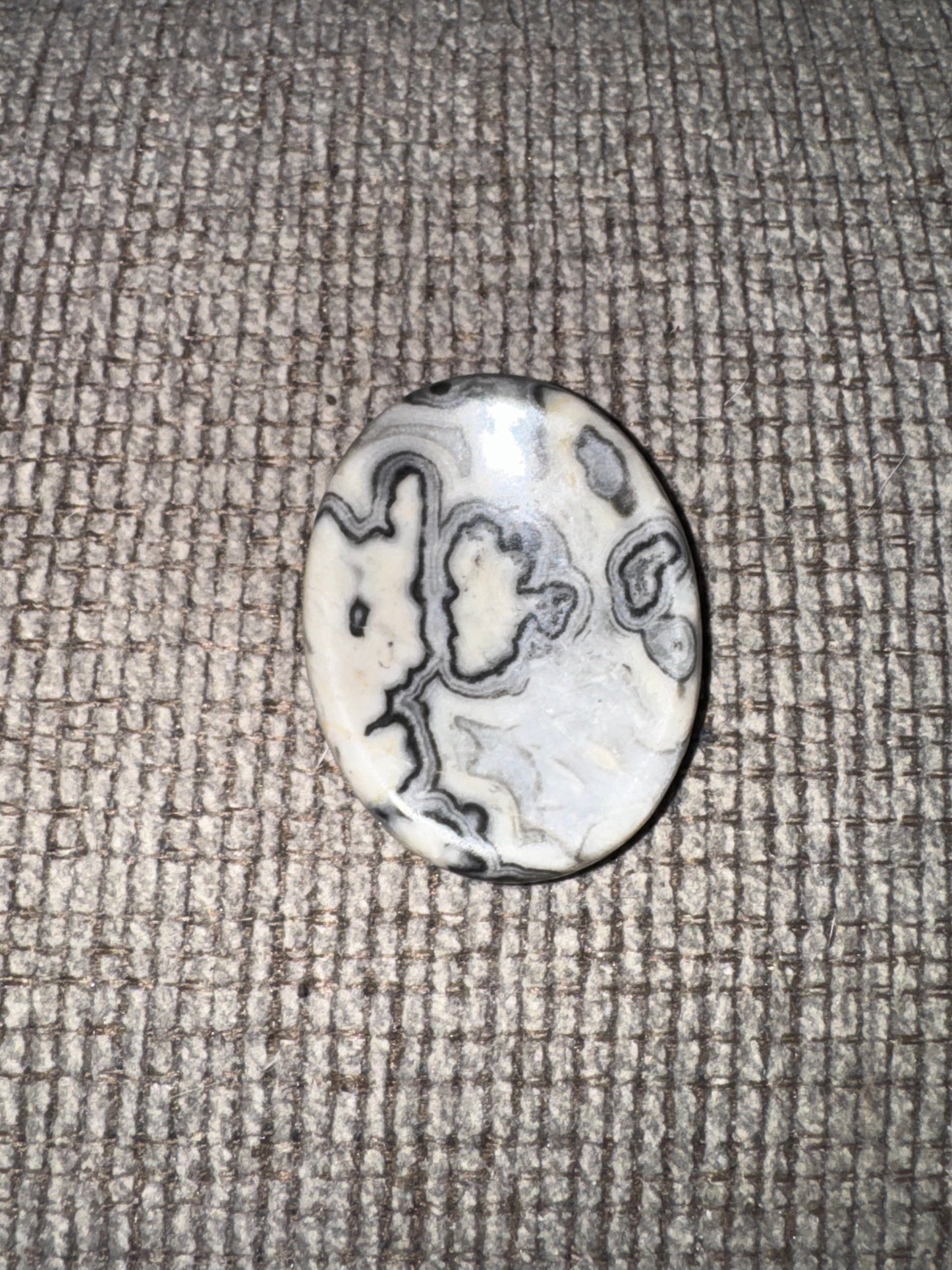 Decorative stone with swirling patterns on a textured surface
