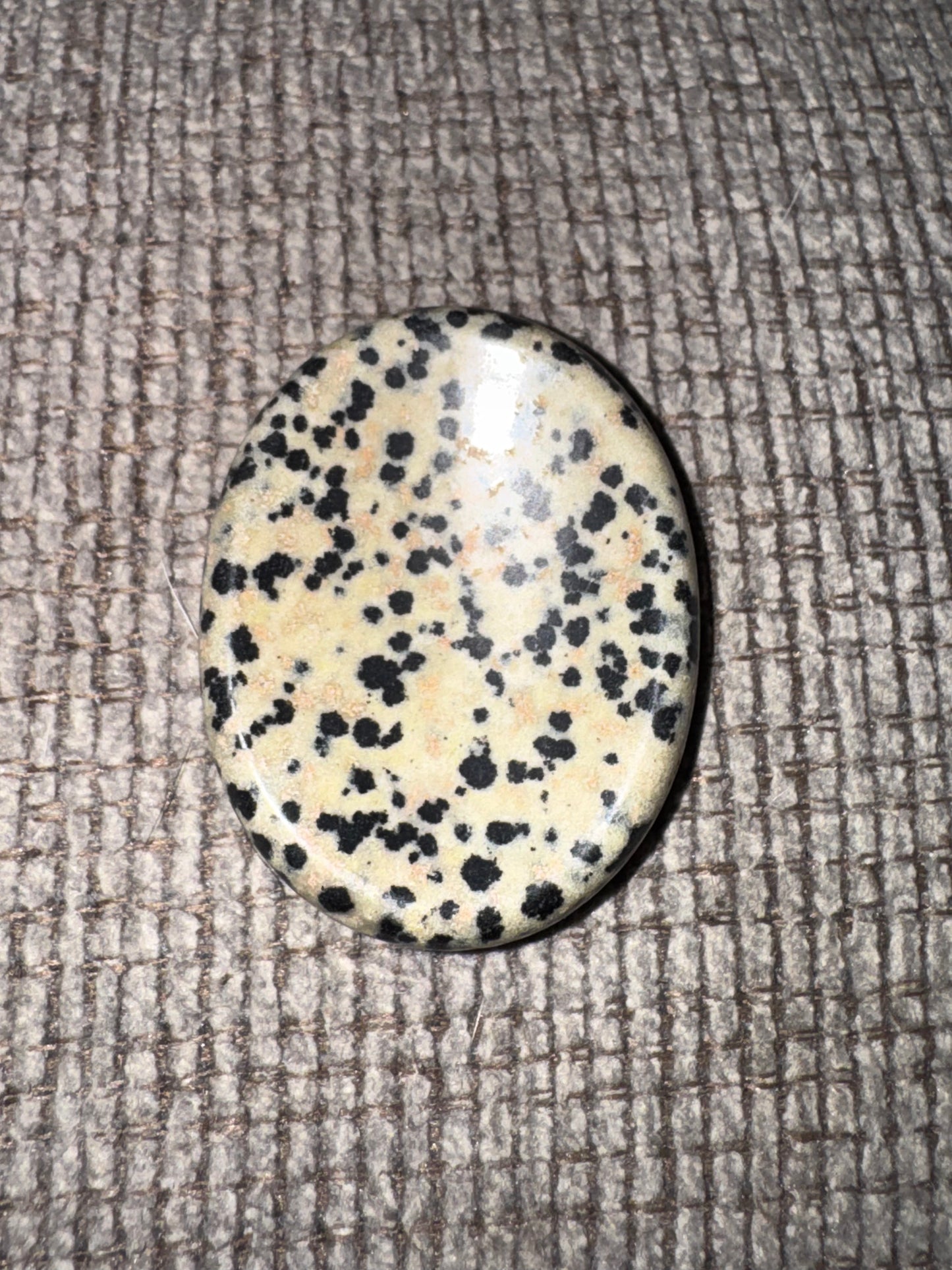 Speckled stone on a textured fabric background