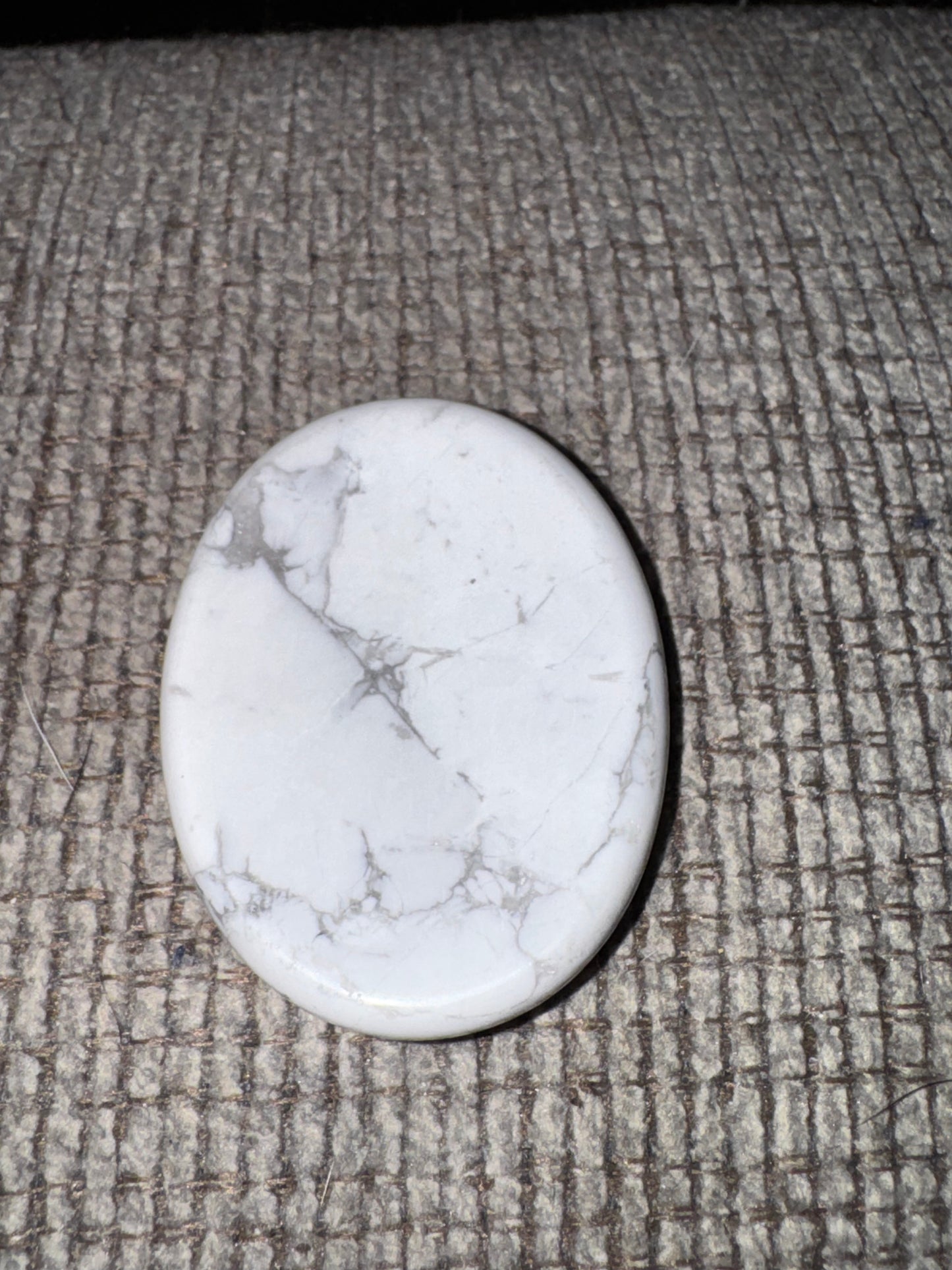 Oval-shaped white stone on a textured gray surface
