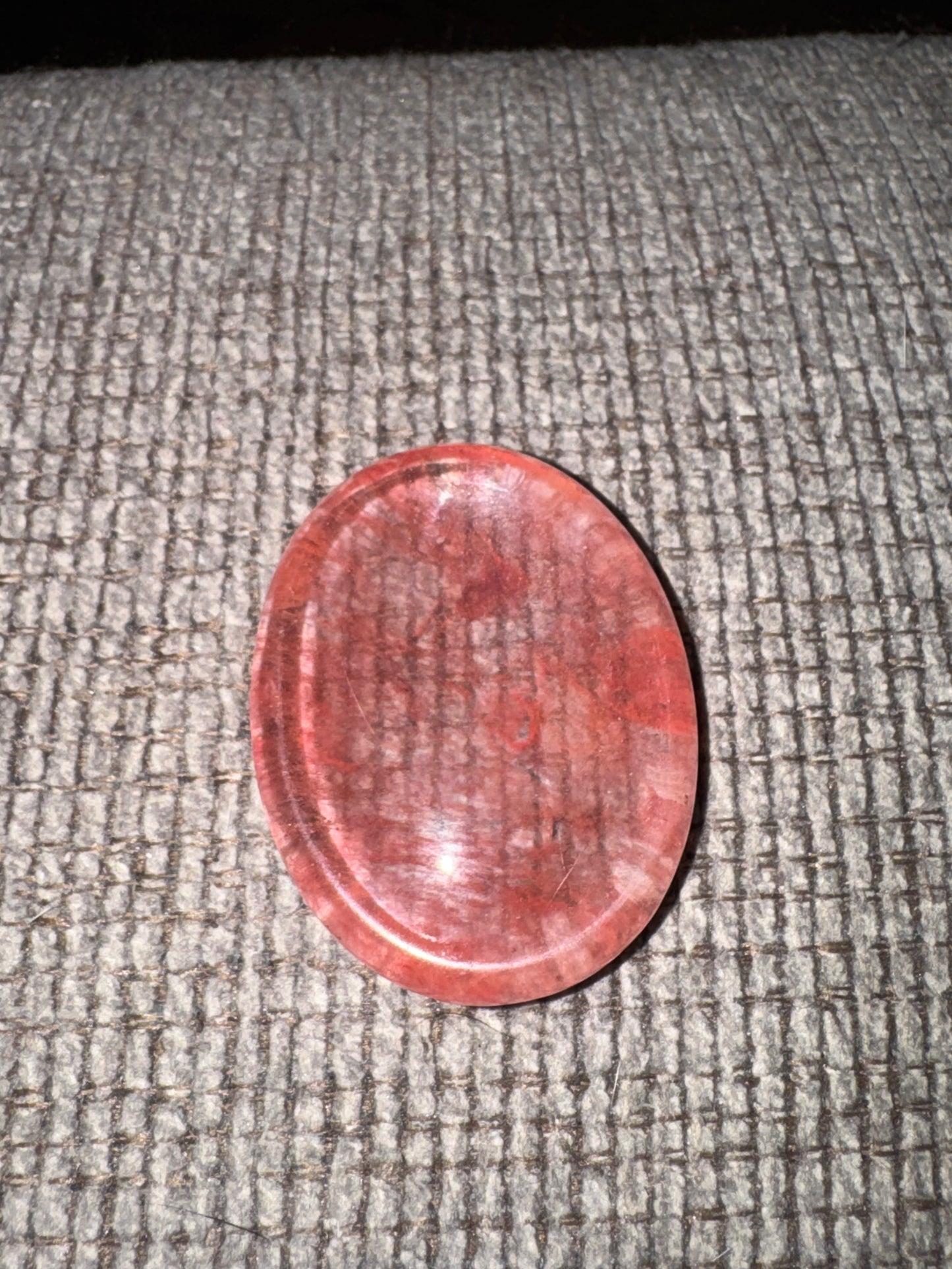 Red circular stone on a textured gray surface