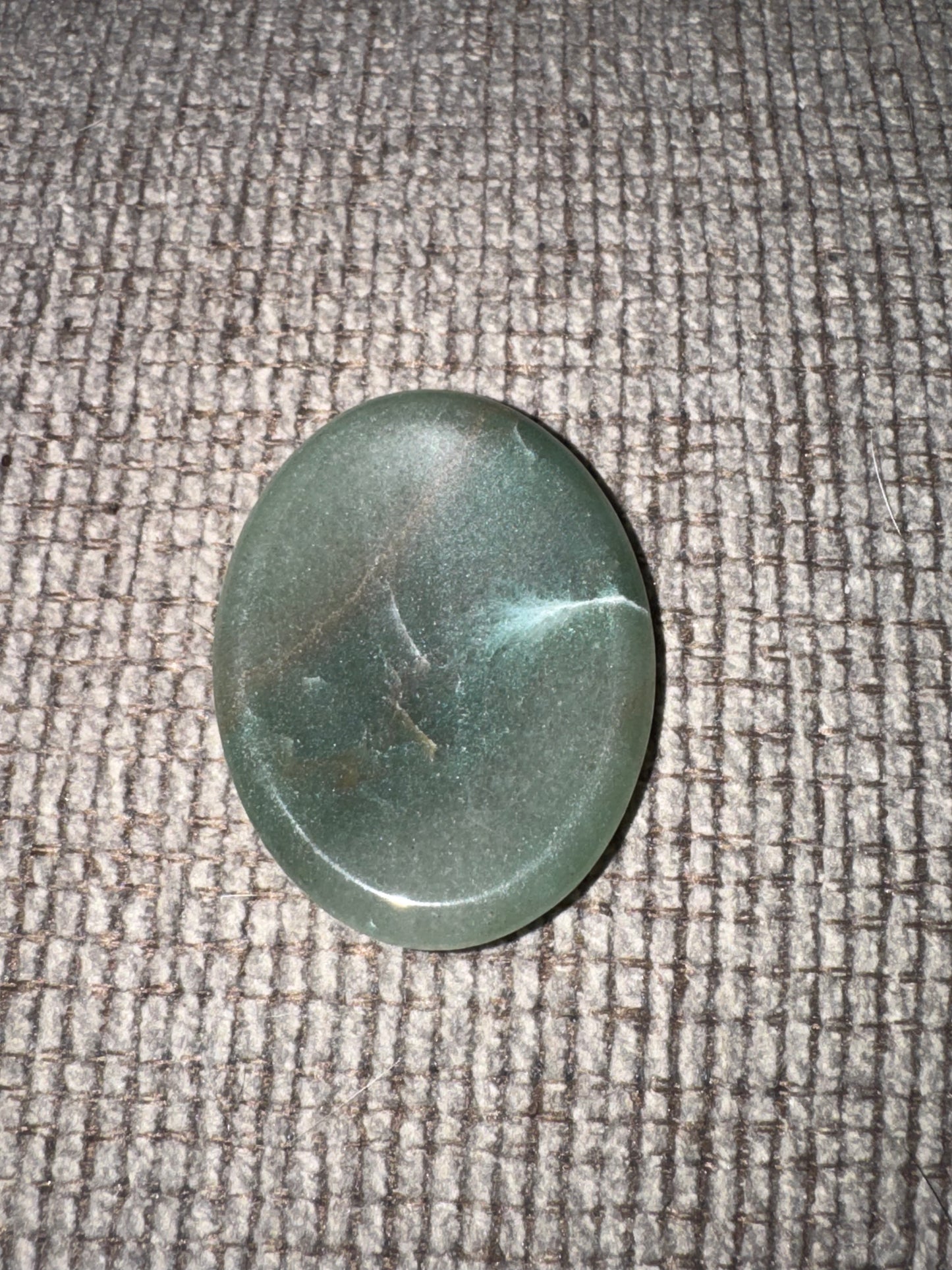 Green stone on a textured gray surface