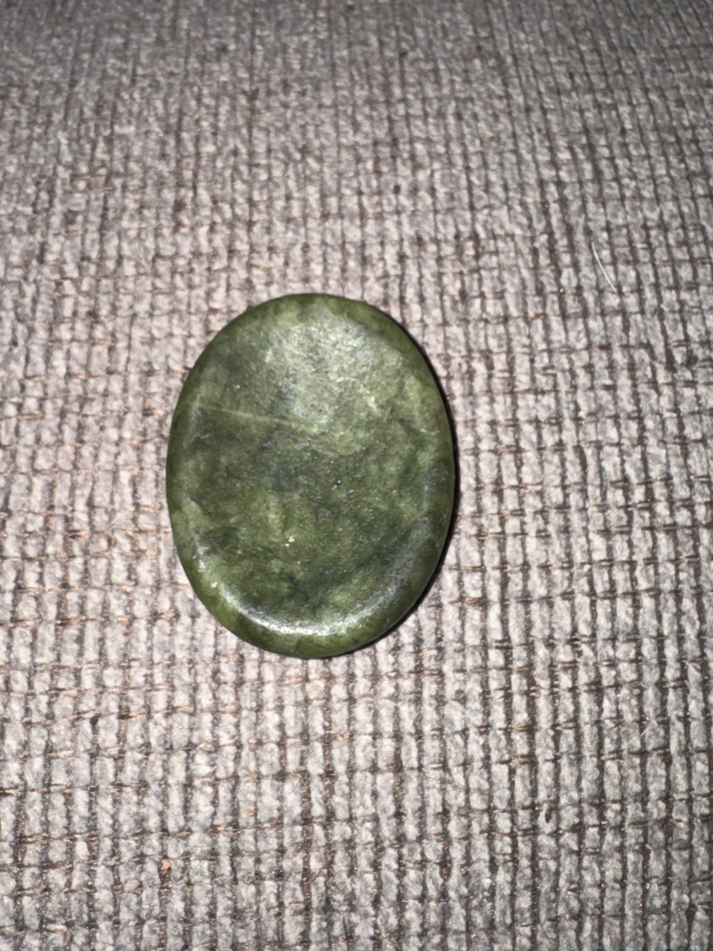 Green stone on a textured fabric surface