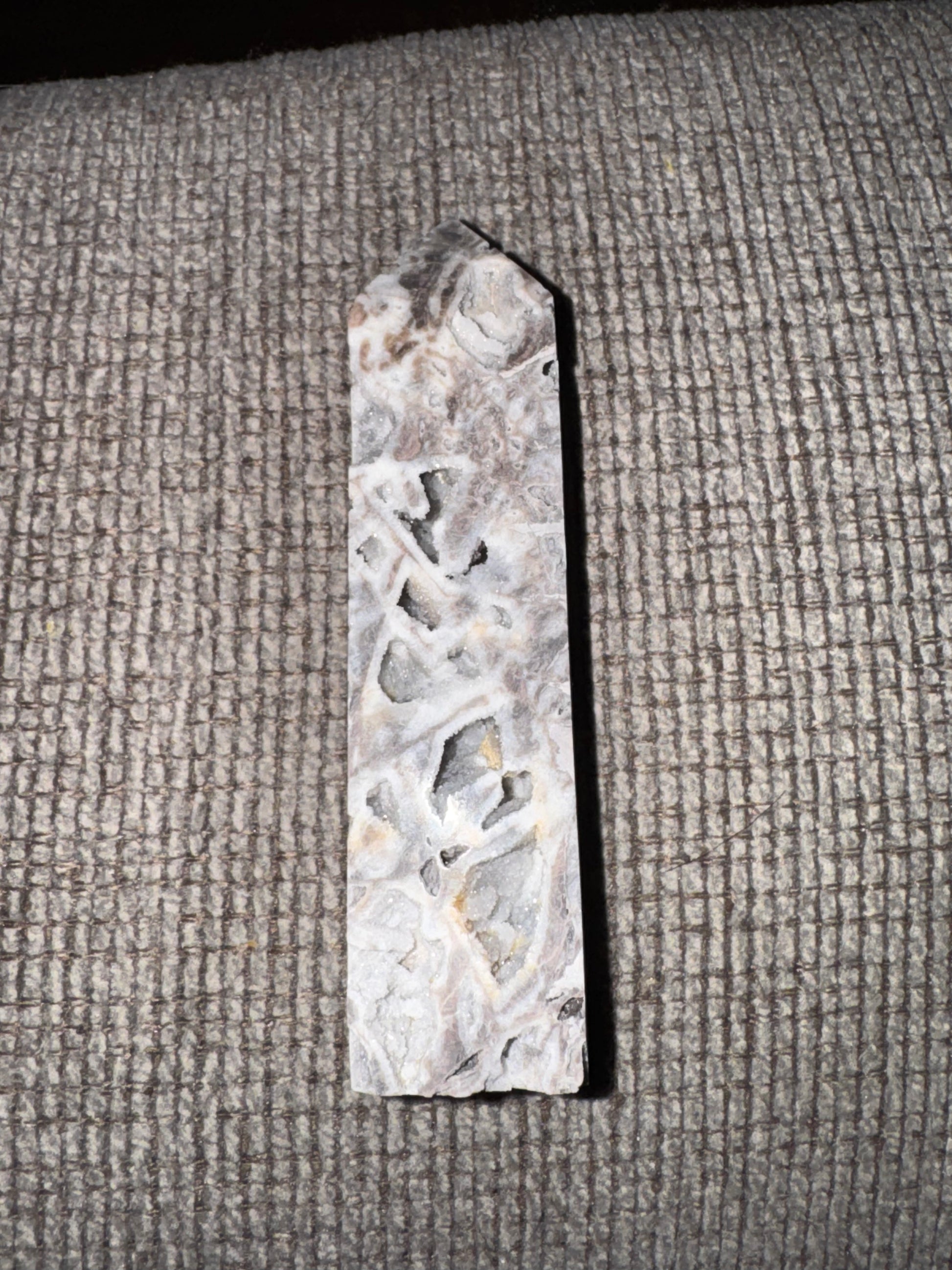 Decorative stone with intricate carvings on a textured surface