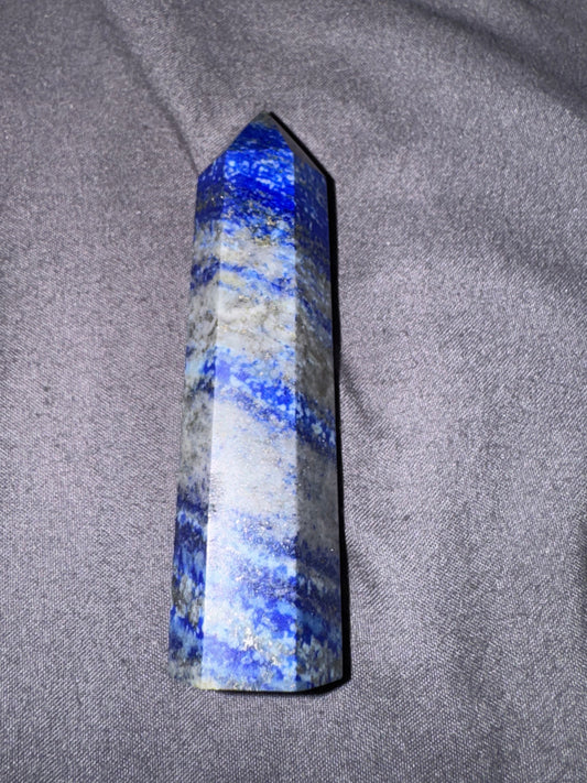 Blue and white striped crystal on a gray fabric background