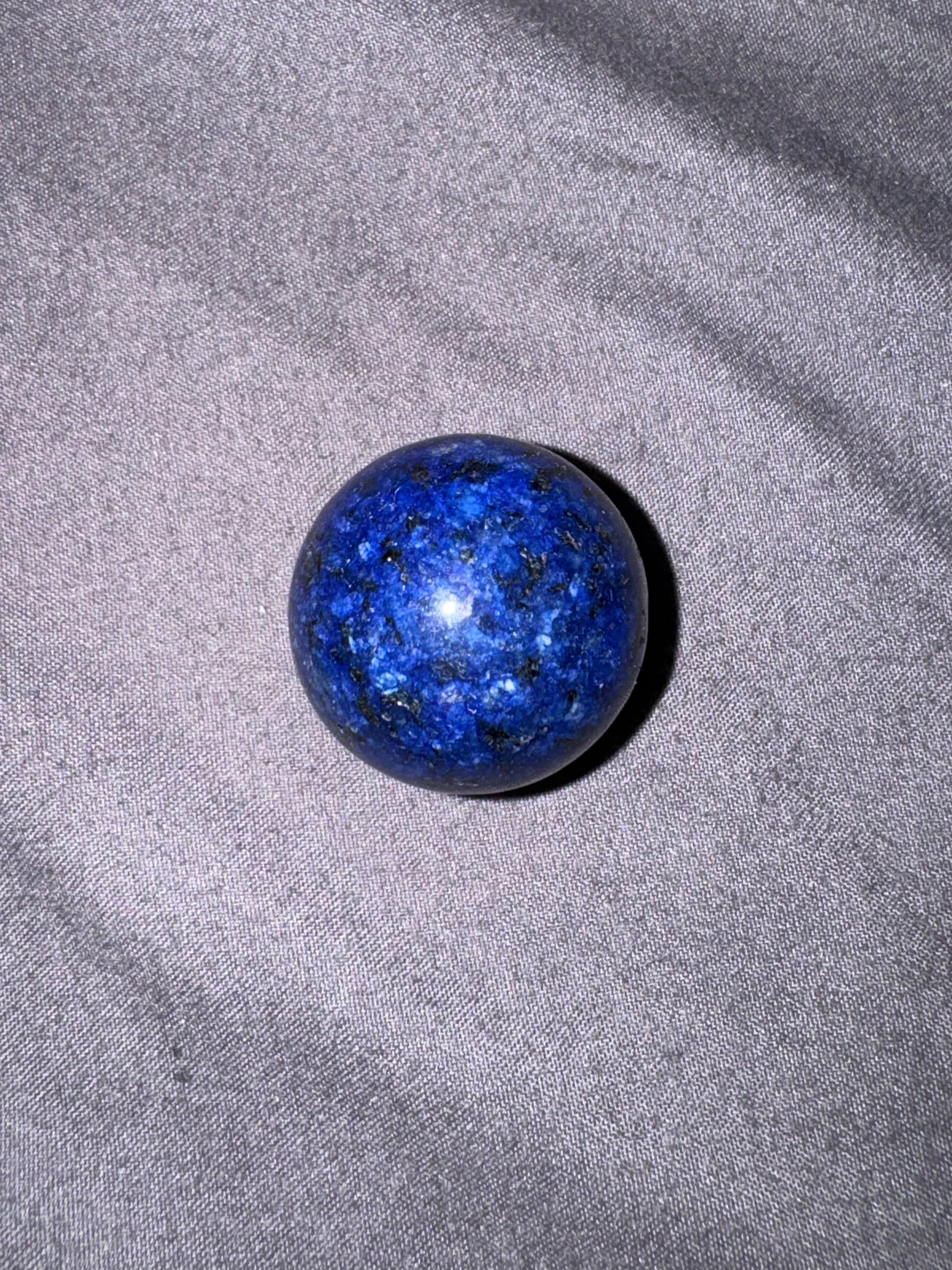 Blue spherical object on a gray fabric background