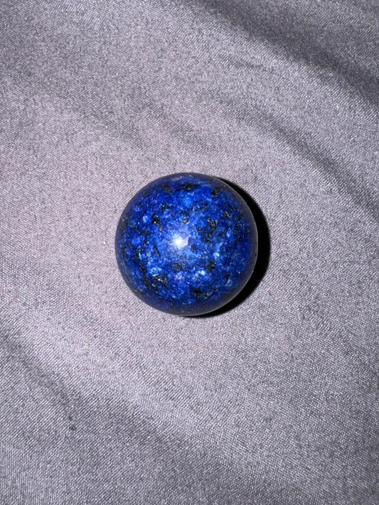 Blue spherical object on a gray fabric background
