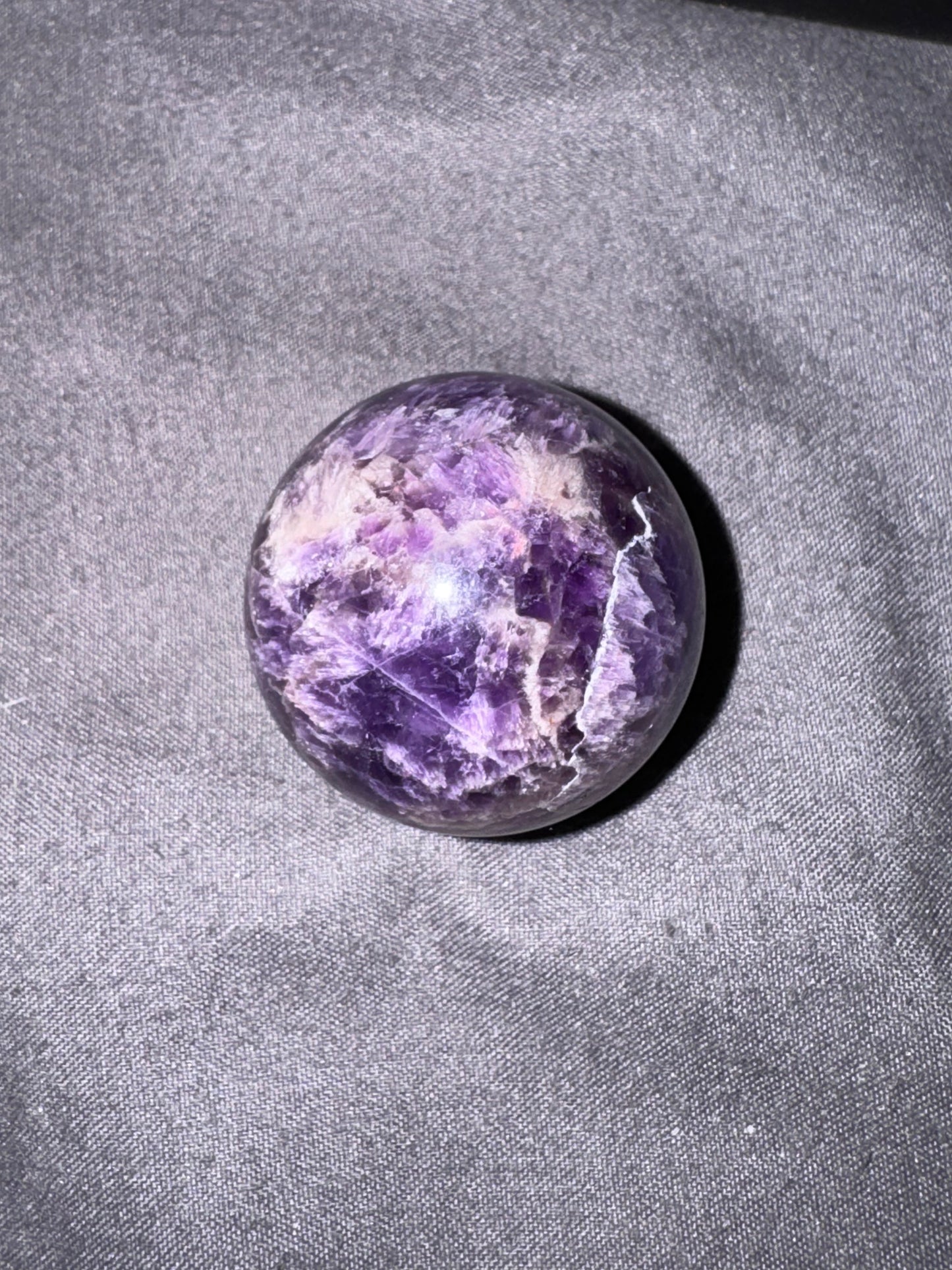 Purple crystal stone on a gray fabric background