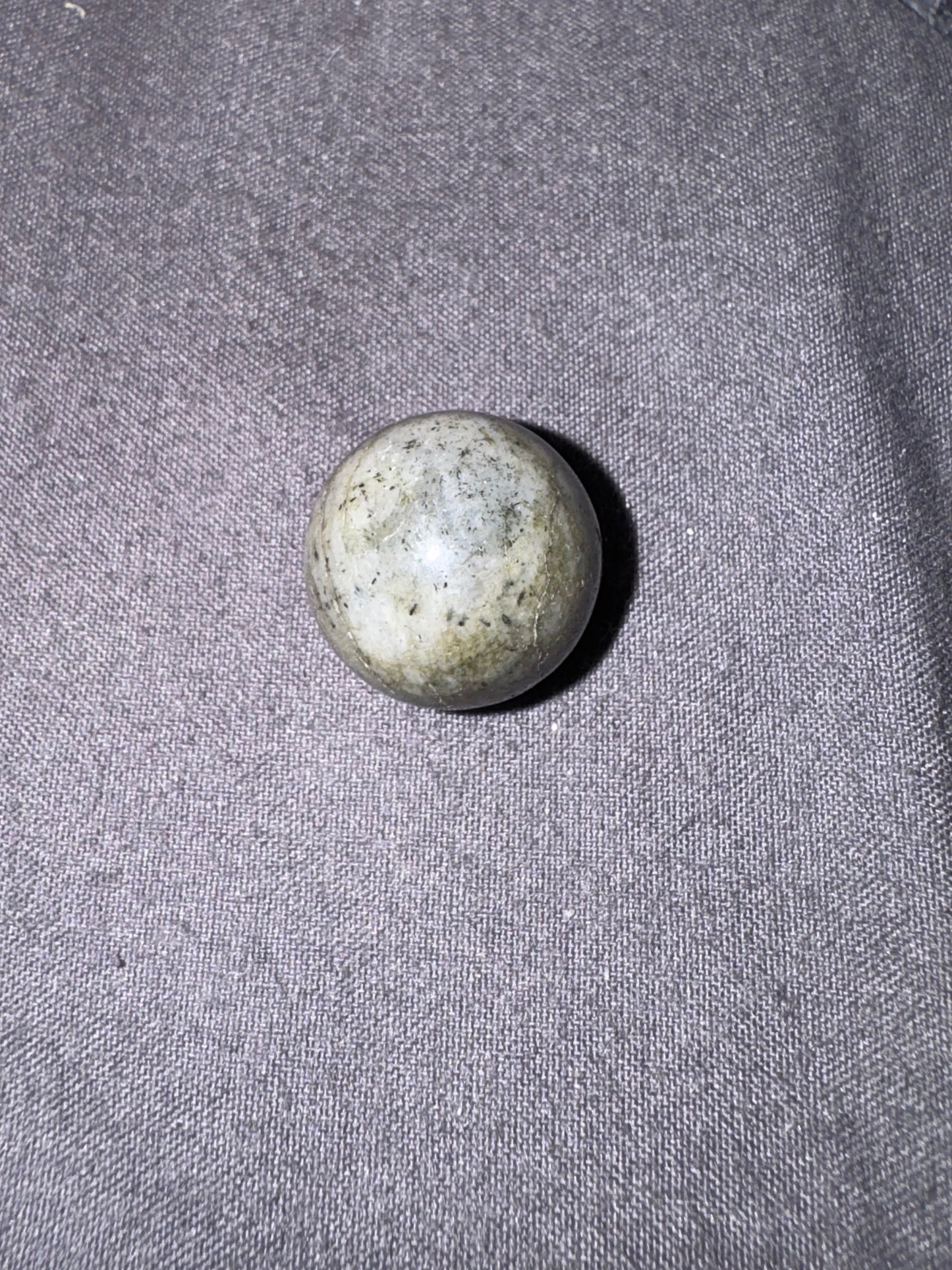 Labradorite stone on a textured gray fabric background