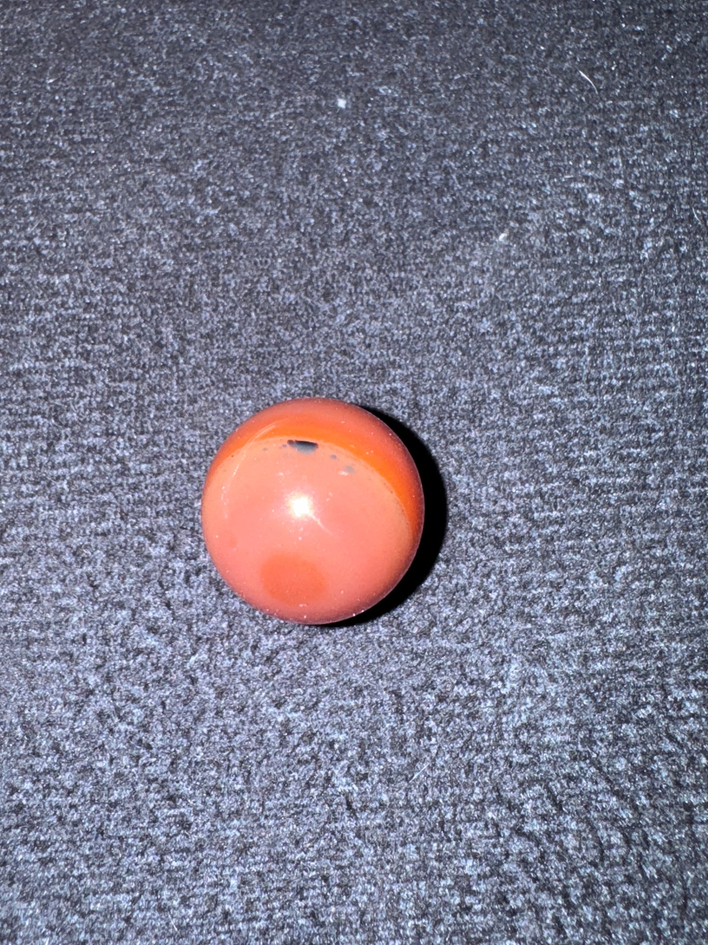 Orange stone on a textured gray surface