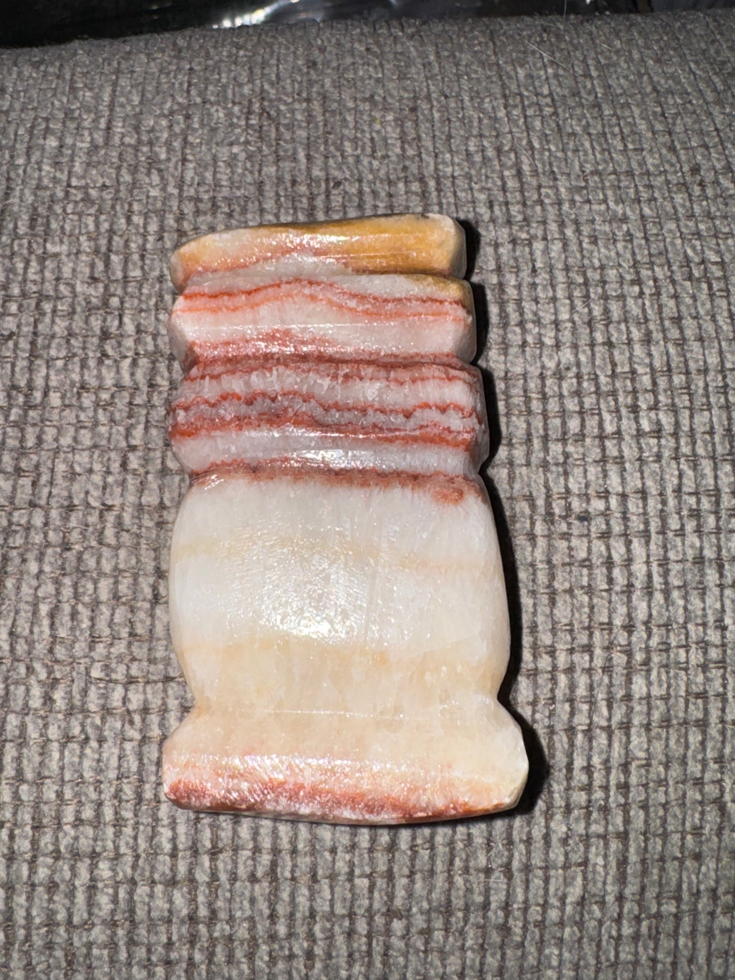 Pork stone with striped pattern on a textured surface