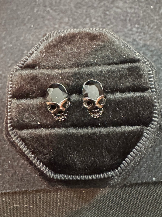 Skull-shaped earrings in a black velvet display box